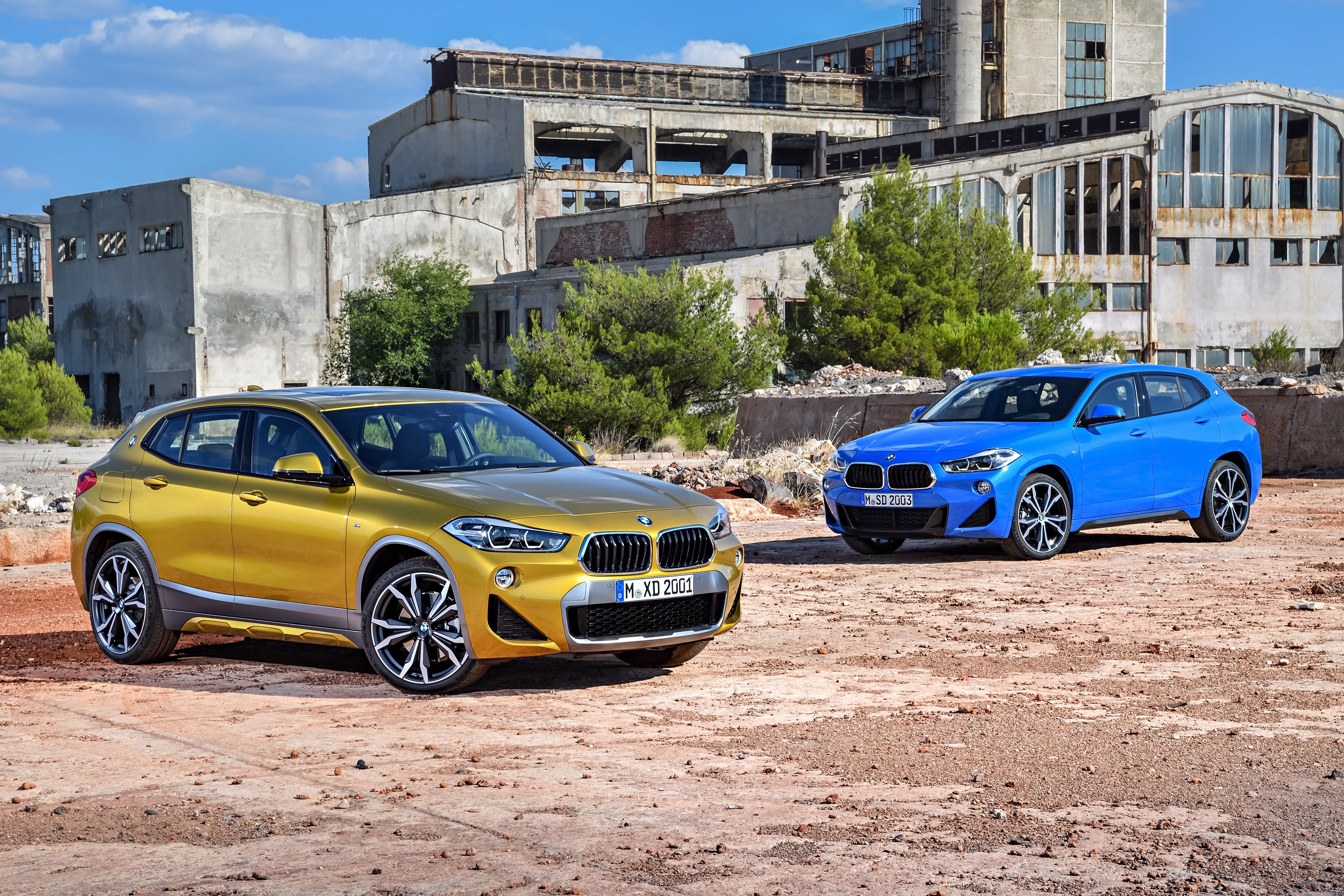 Two BMW X2 cars in front of abandoned building HD Wallpaper