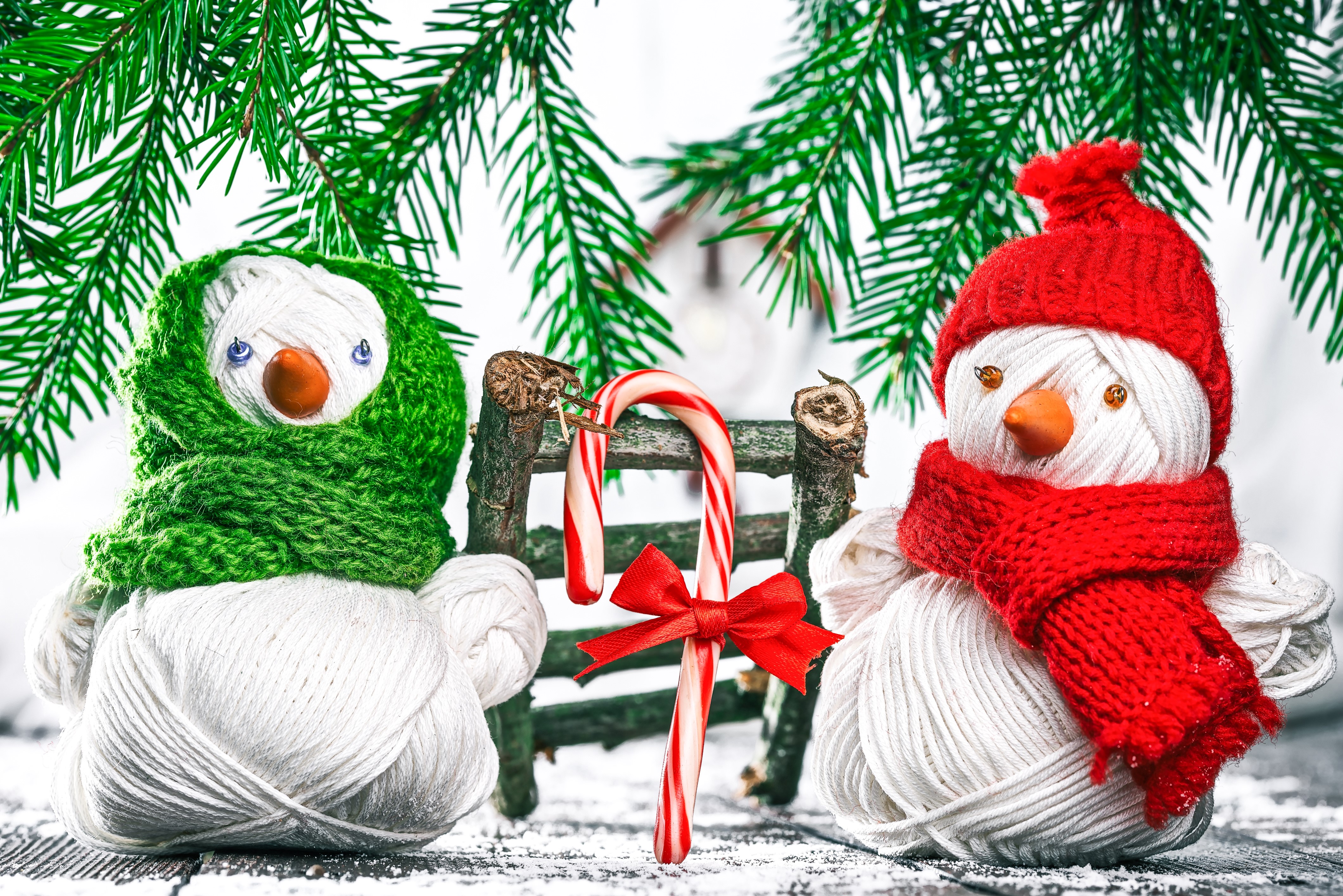 Two snowmen with candy cane and pine branches HD Wallpaper