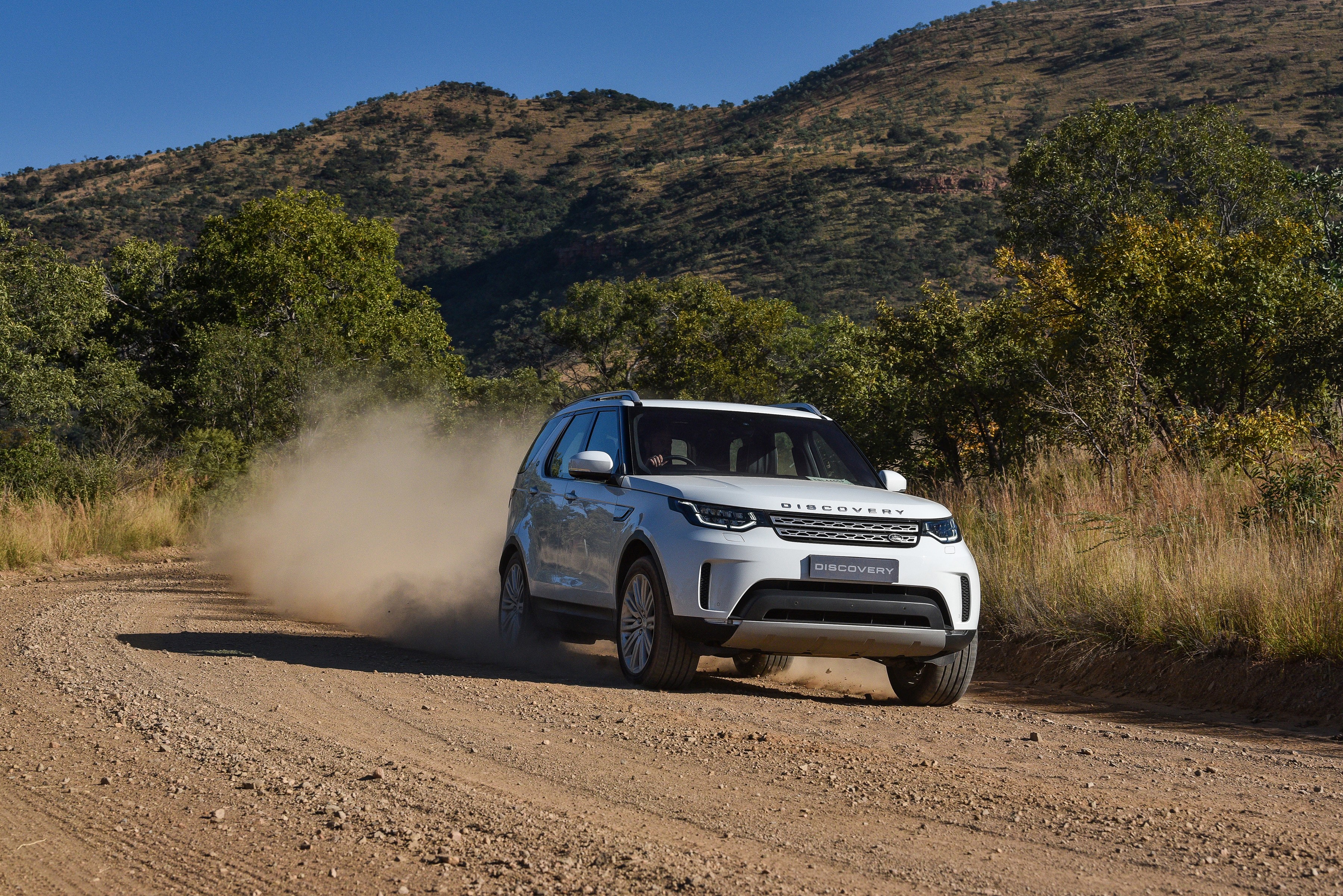 White Land Rover Discovery driving on a dirt road HD Wallpaper