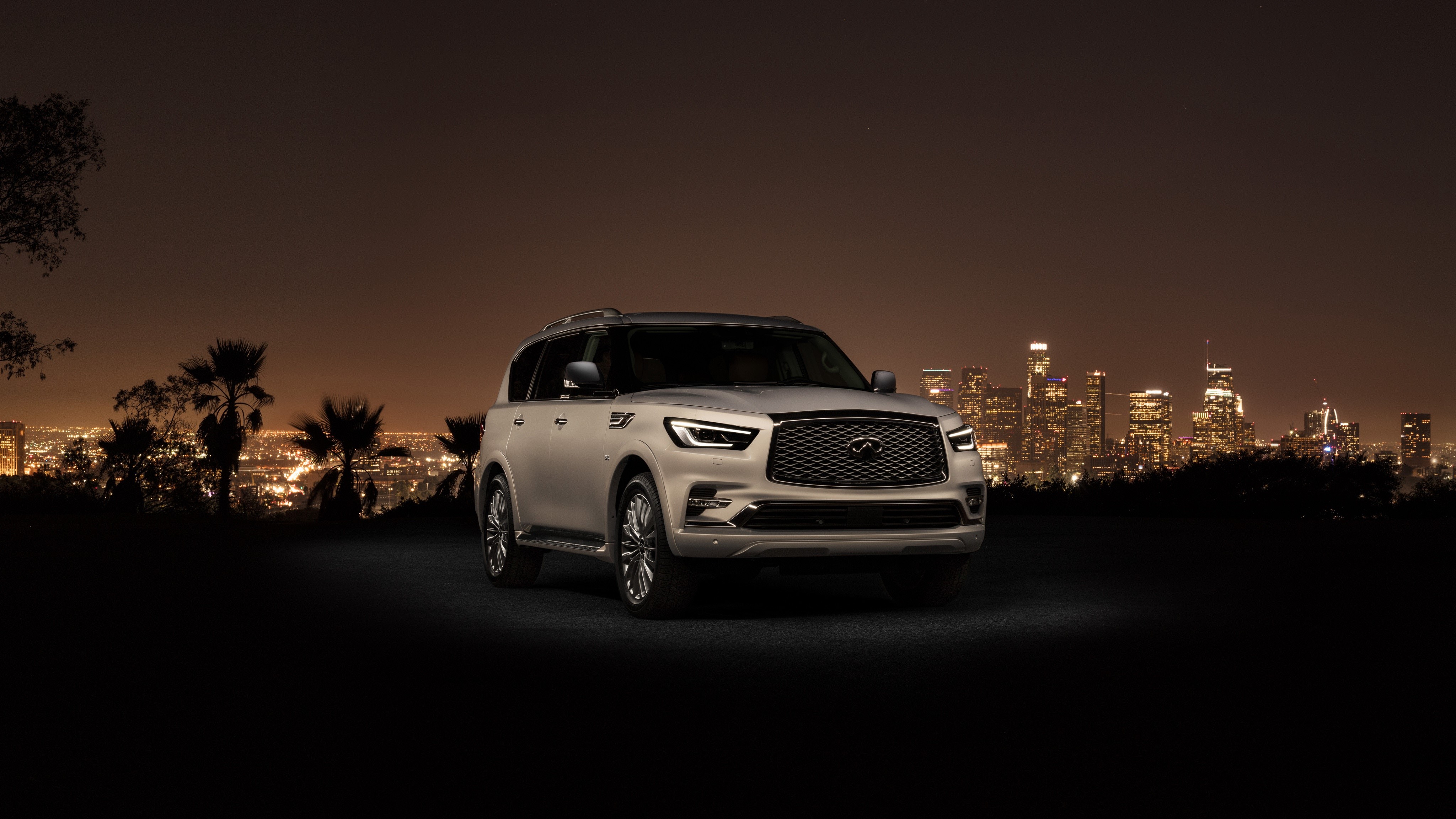 Infiniti QX80 2018 in front of city skyline HD Wallpaper