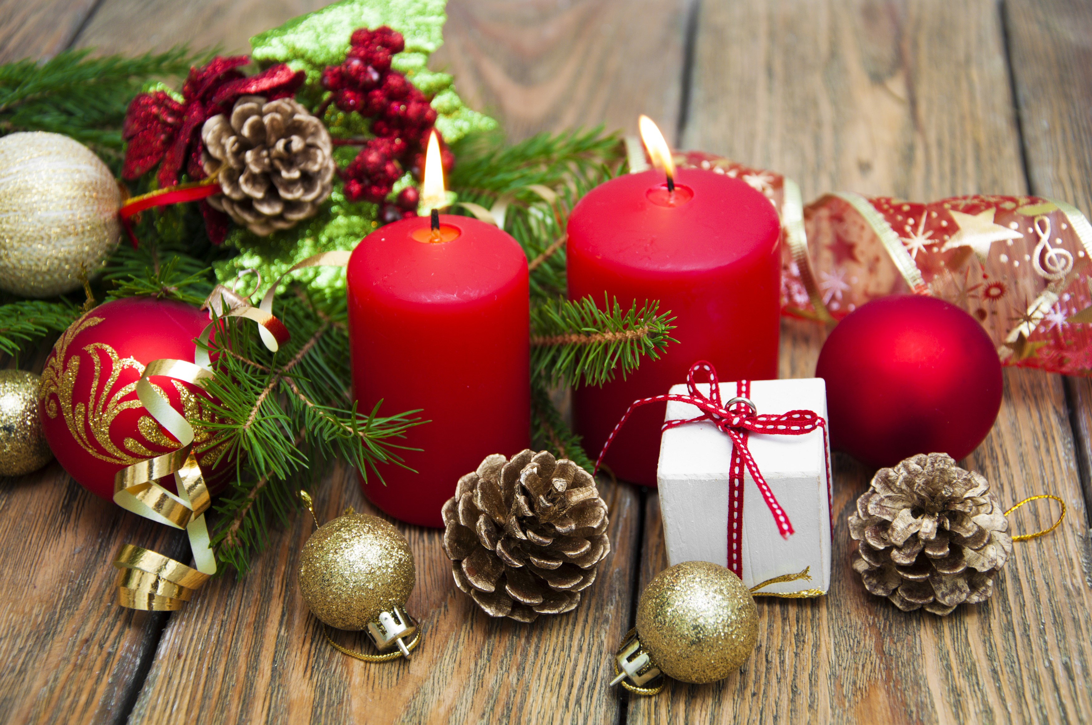 Christmas candles with ornaments and pine cones on wood HD Wallpaper