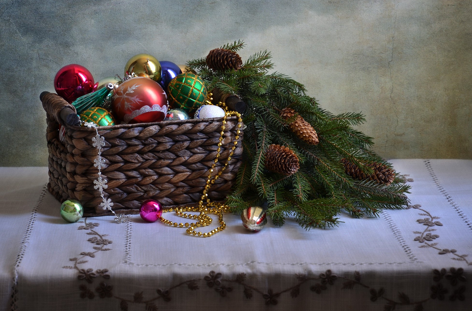 Christmas ornaments in a wicker basket with pine cones and branches HD Wallpaper