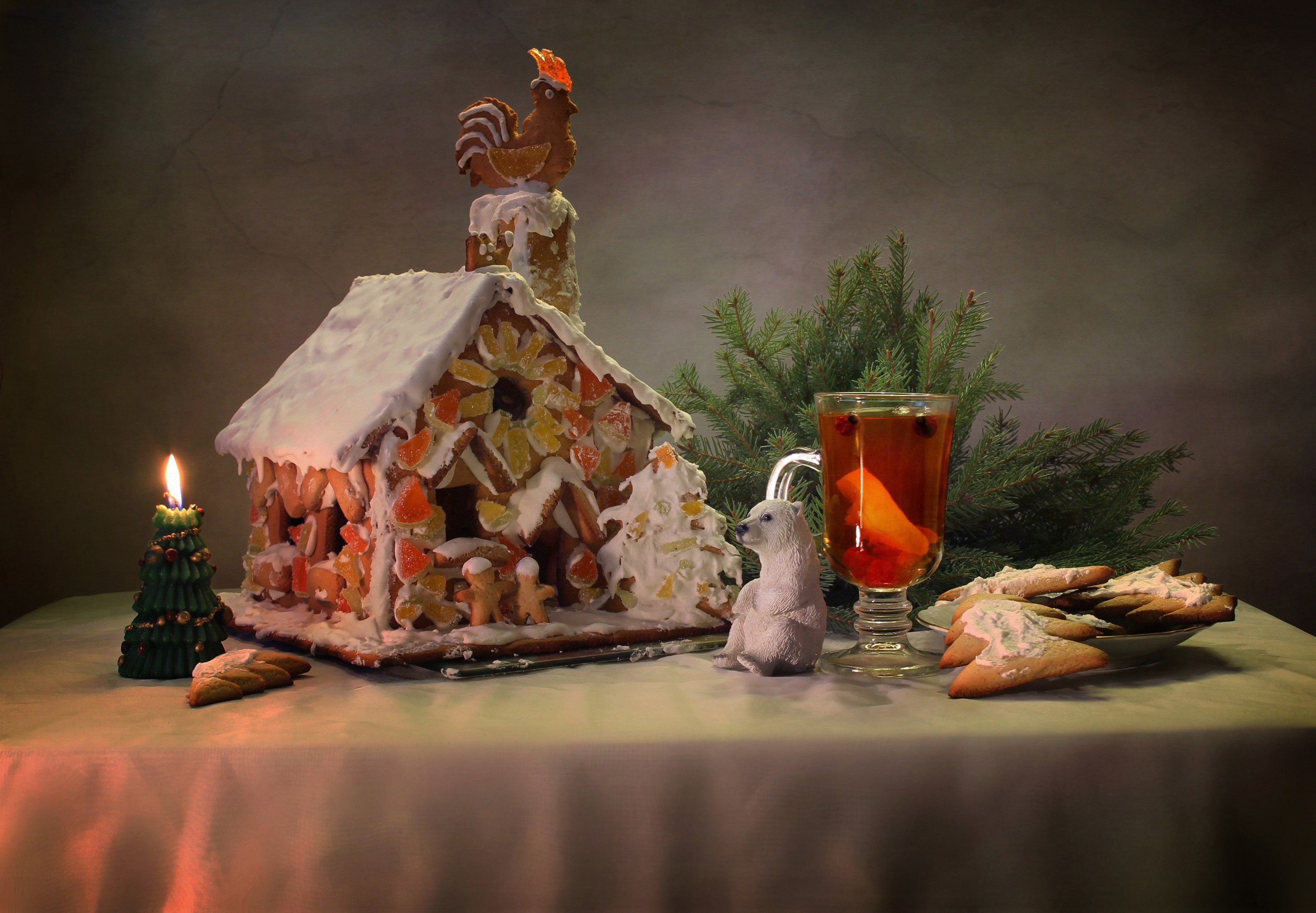 Christmas gingerbread house with candle, drink, and cookies HD Wallpaper