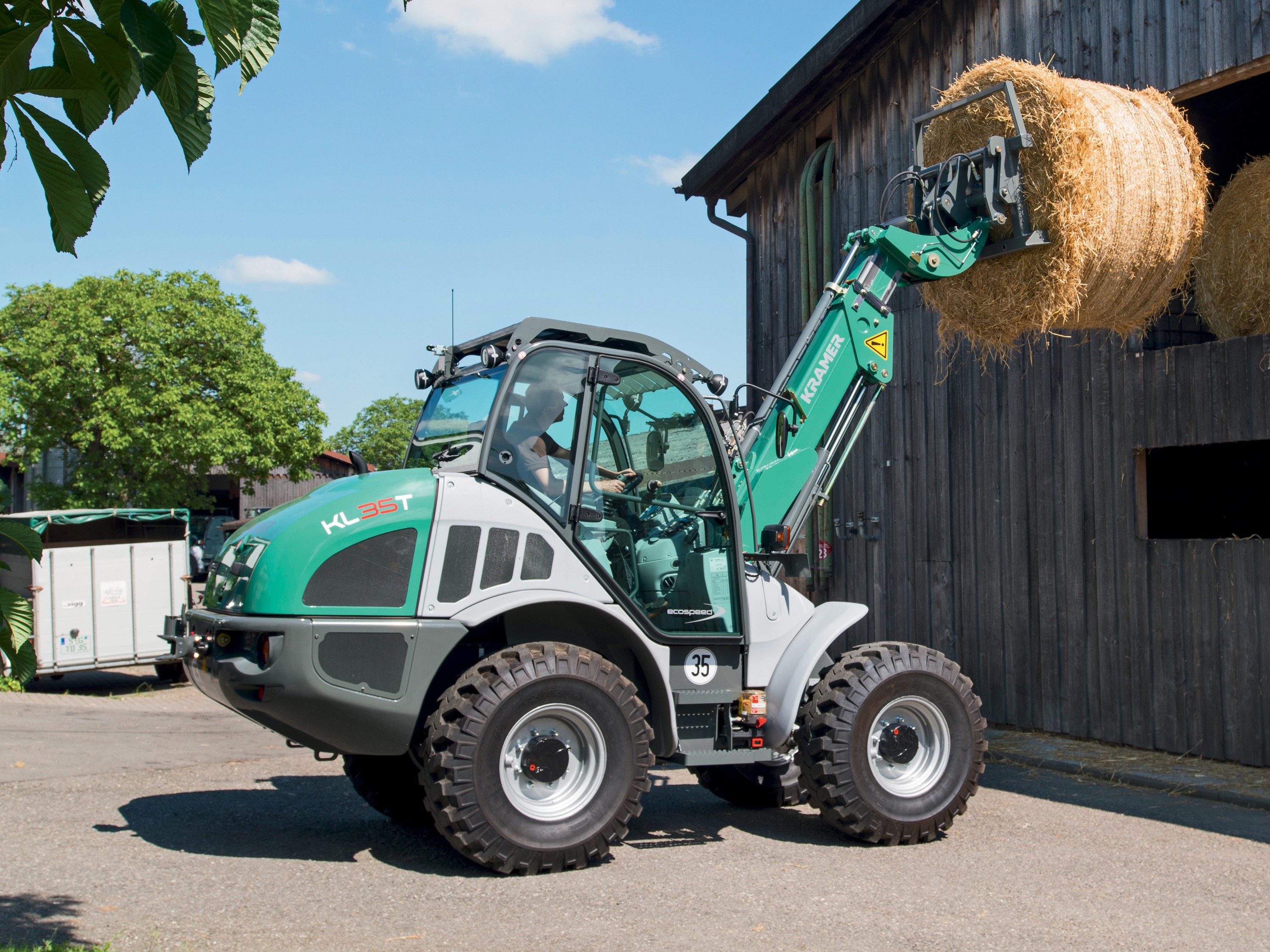 Kramer KL35T loader lifting hay bale HD Wallpaper