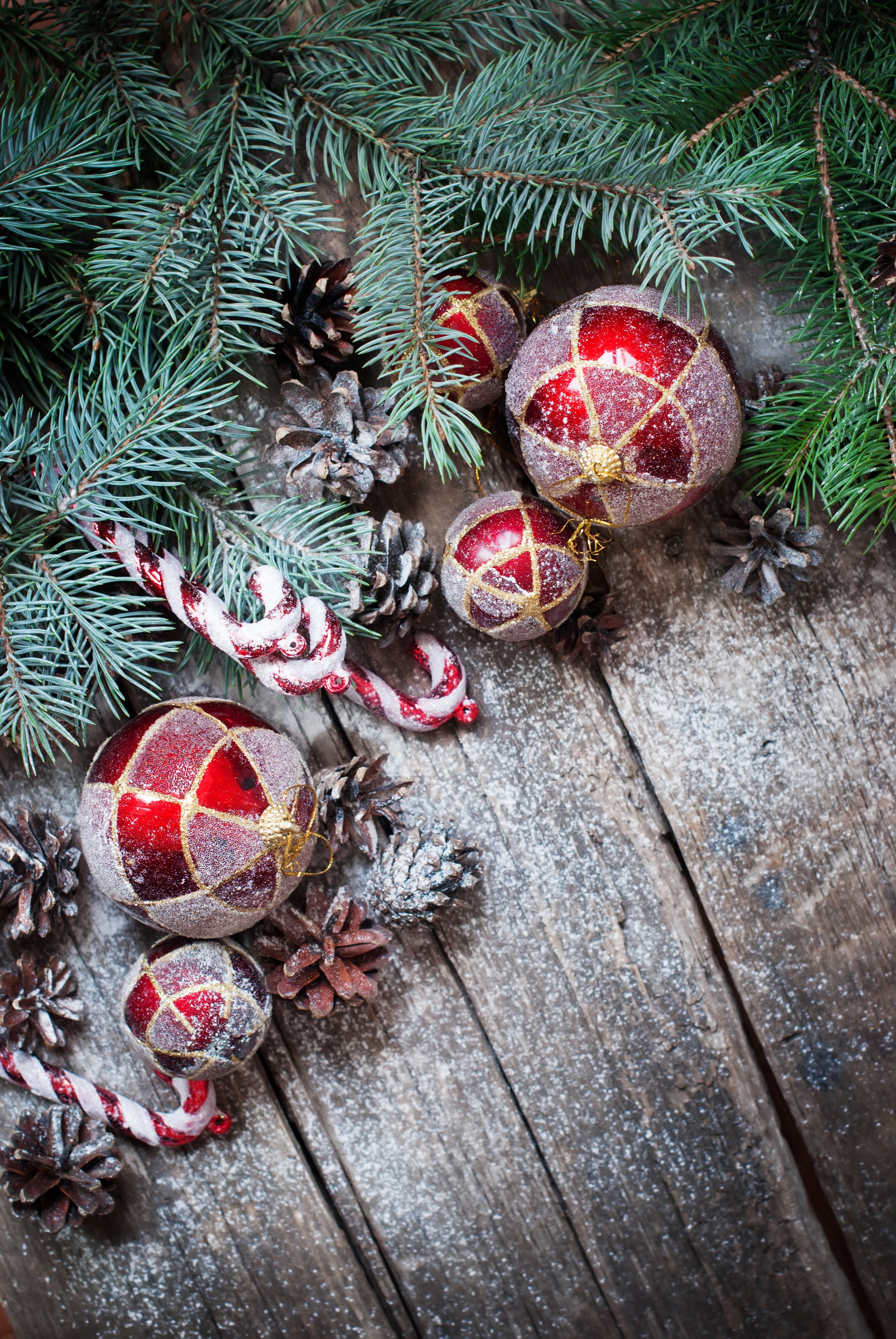 Christmas ornaments, pine cones, and fir branches on wood HD Phone Wallpaper