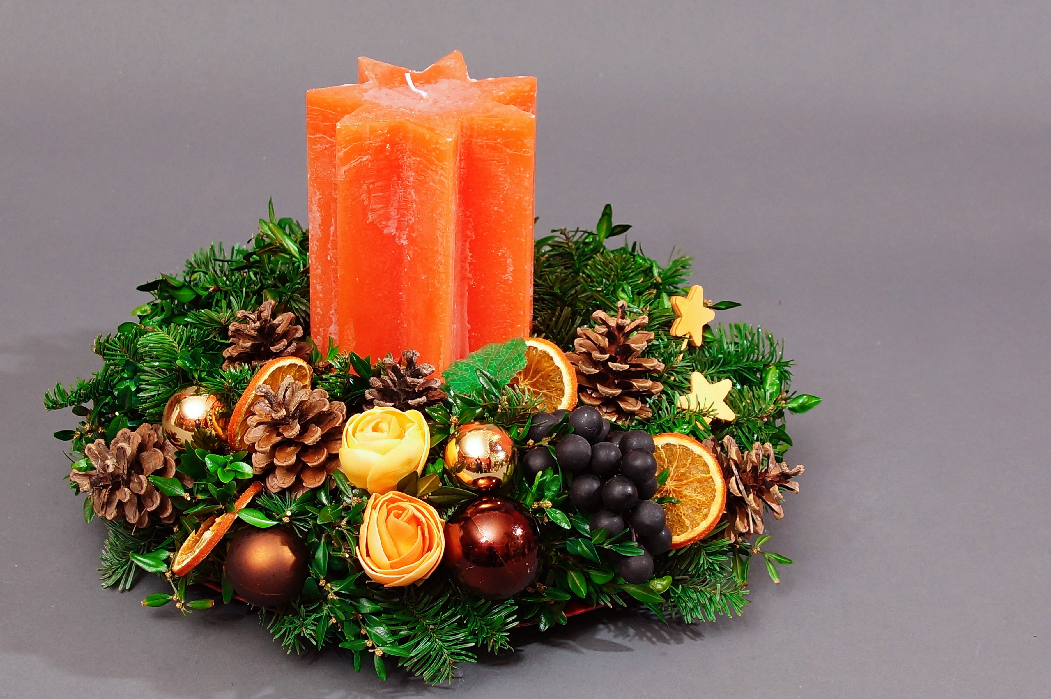 Christmas advent wreath with orange candles and pine cones HD Wallpaper