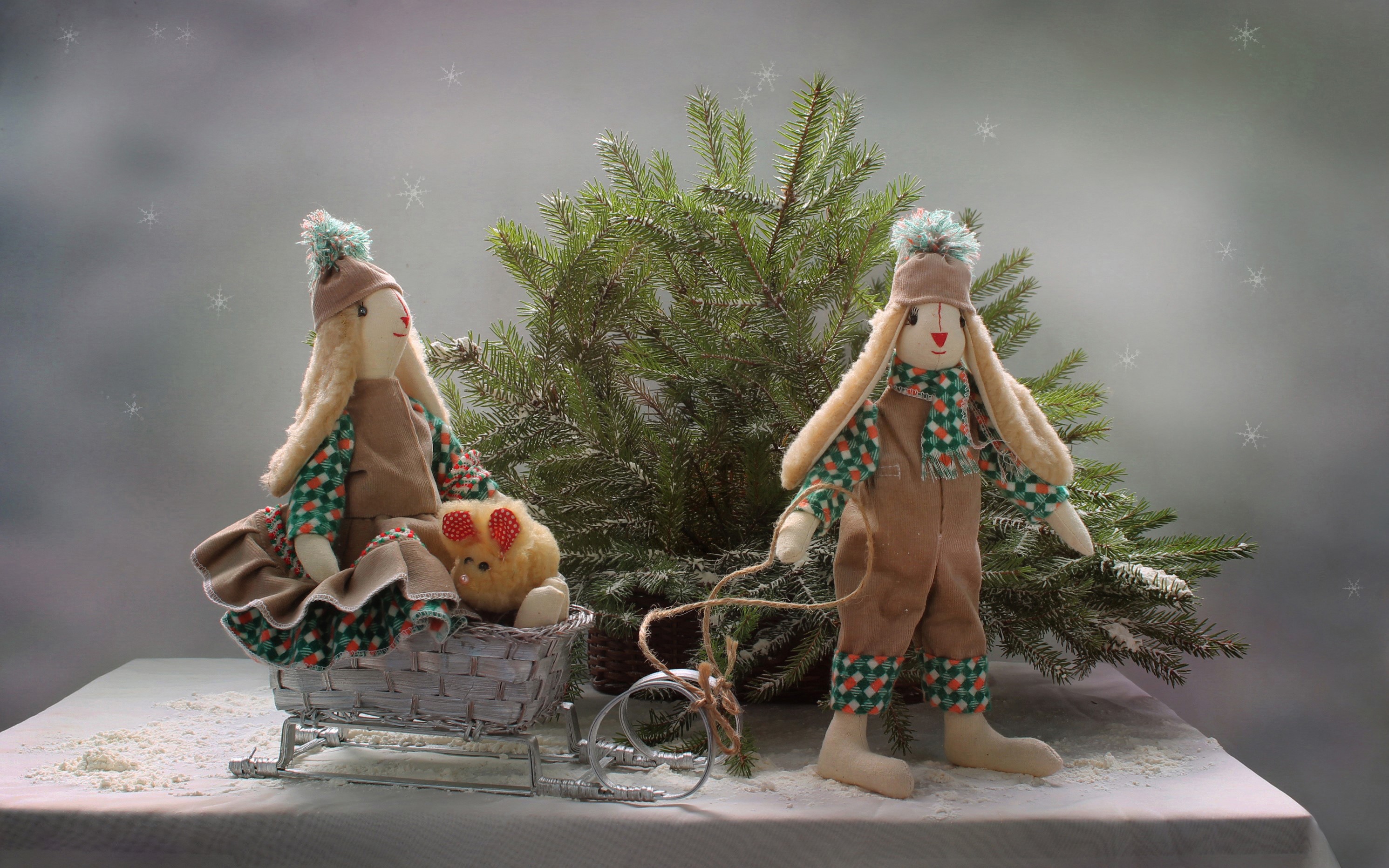 Two bunny dolls in winter attire with a sled and Christmas tree HD Wallpaper
