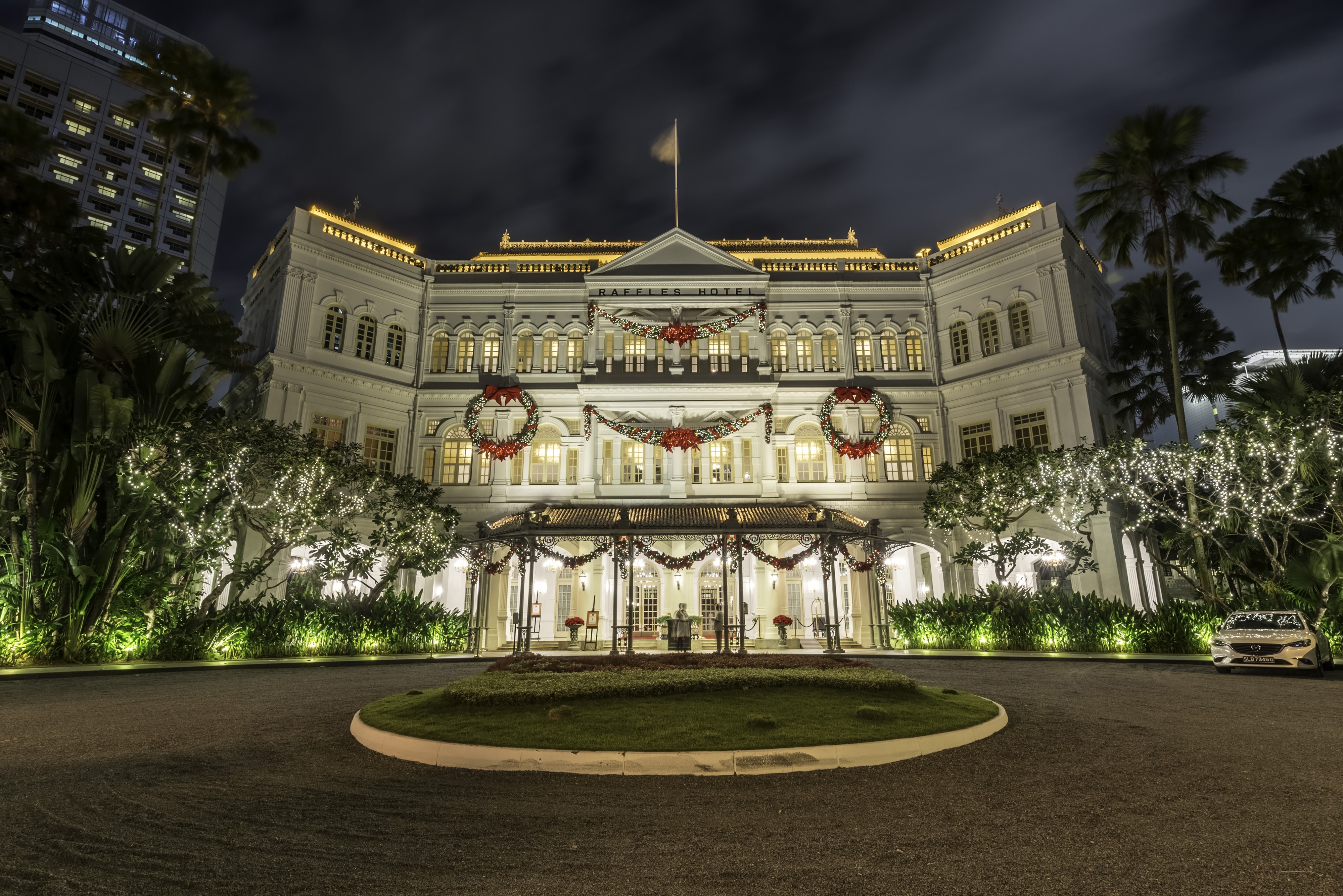 Raffles Hotel Singapore at night with Christmas decorations HD Wallpaper