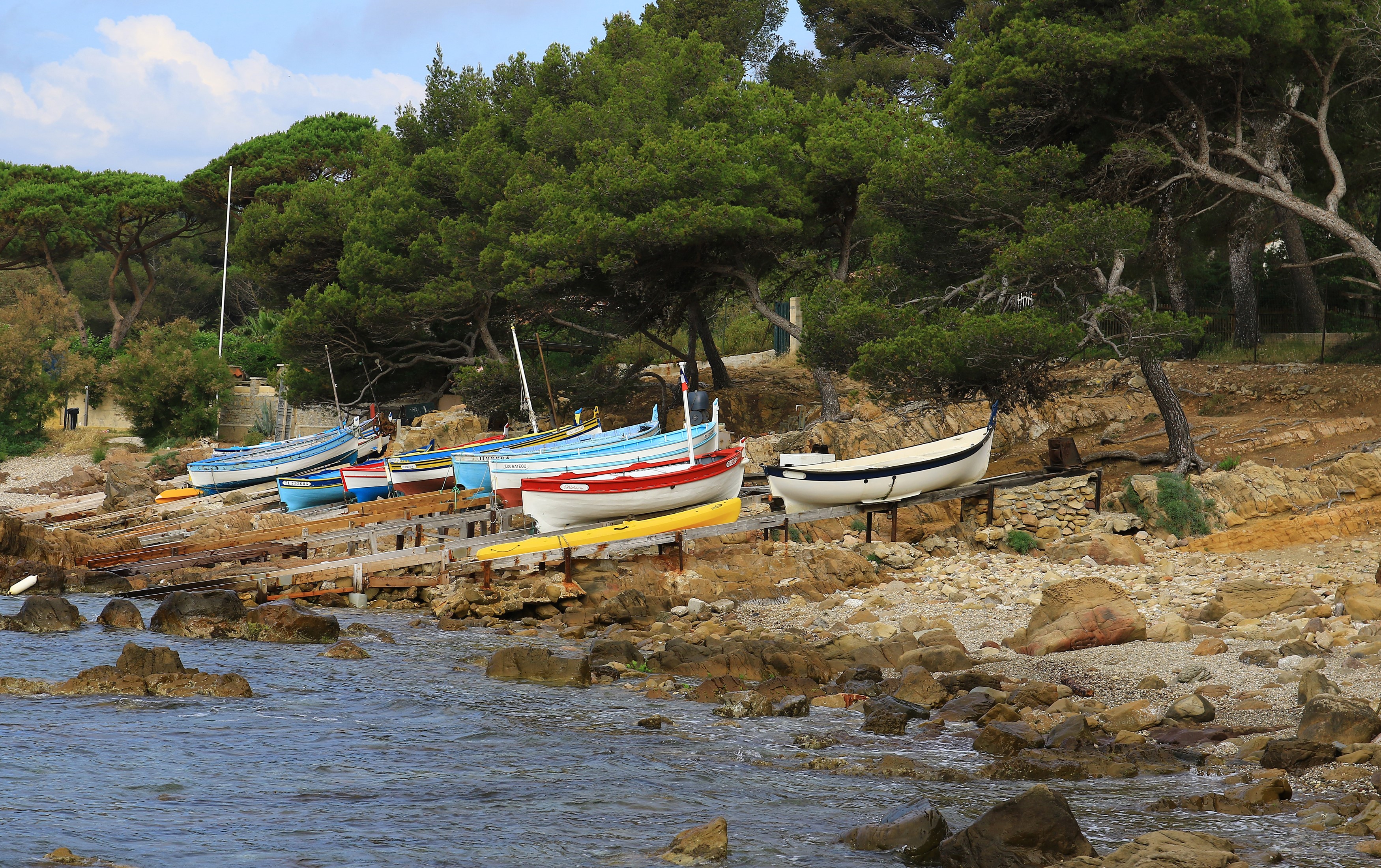 Boats on a rocky shore with pine trees in France HD Wallpaper