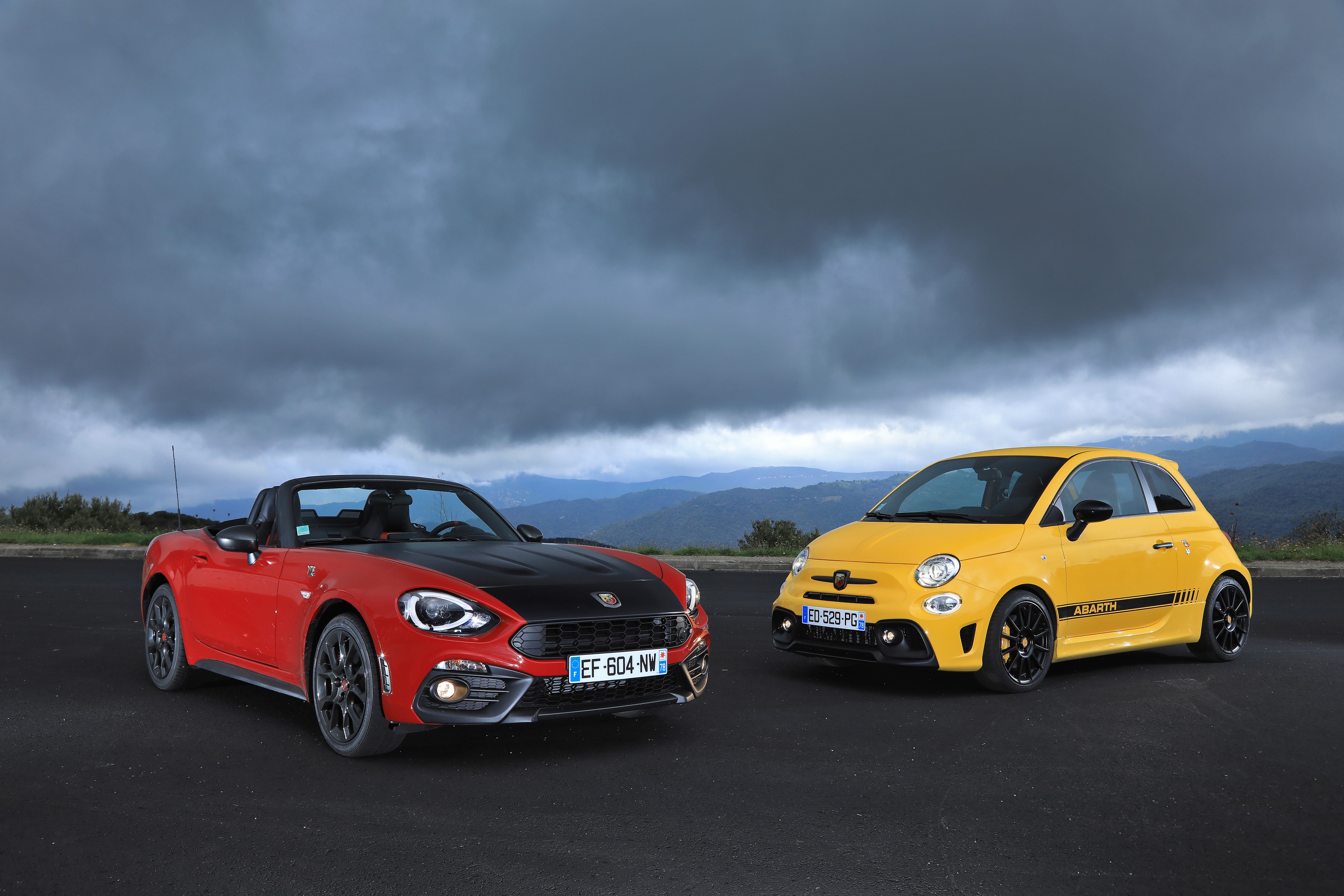 Two Abarth cars, red convertible and yellow hatchback HD Wallpaper