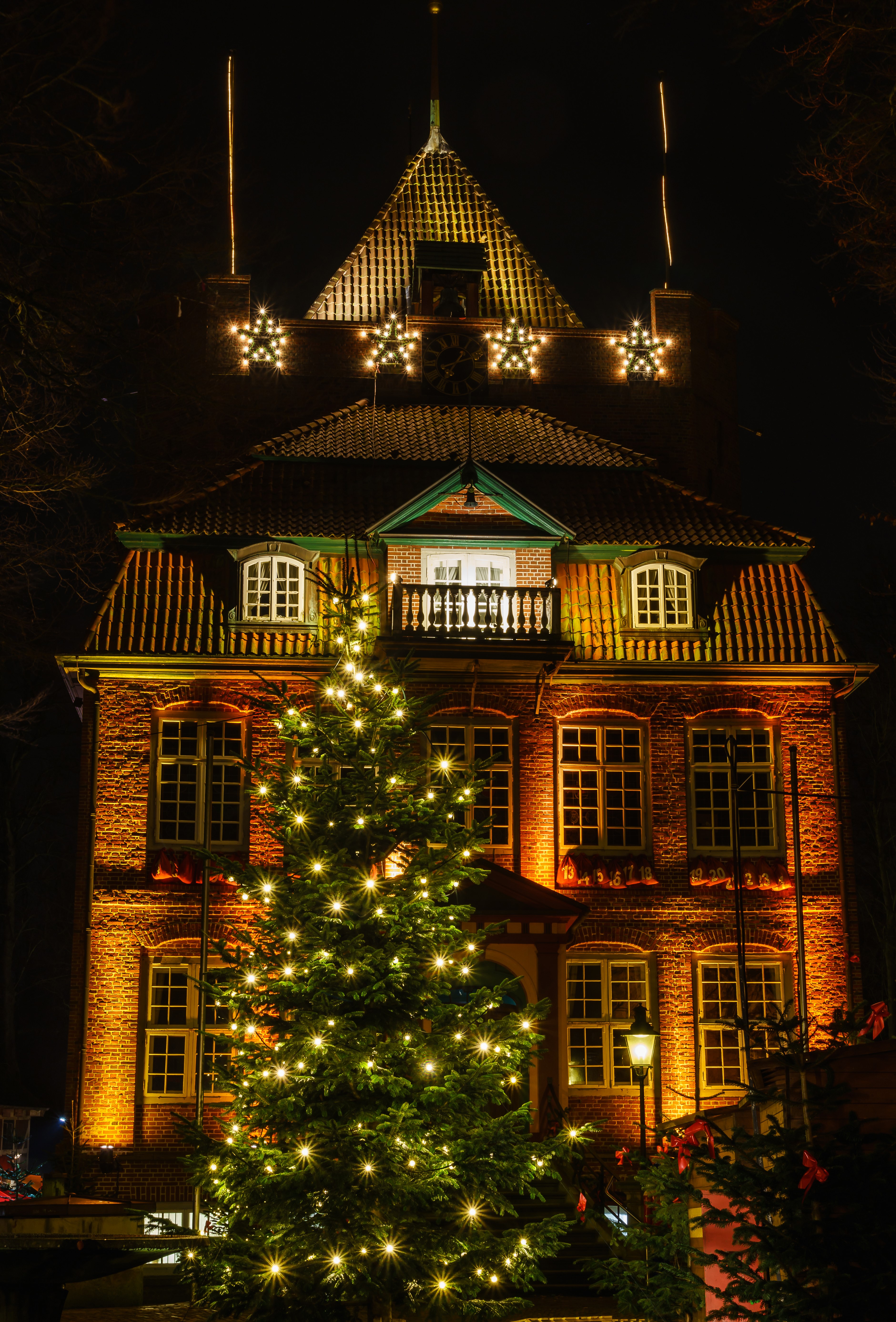 Christmas decorations on a brick building at night HD Phone Wallpaper