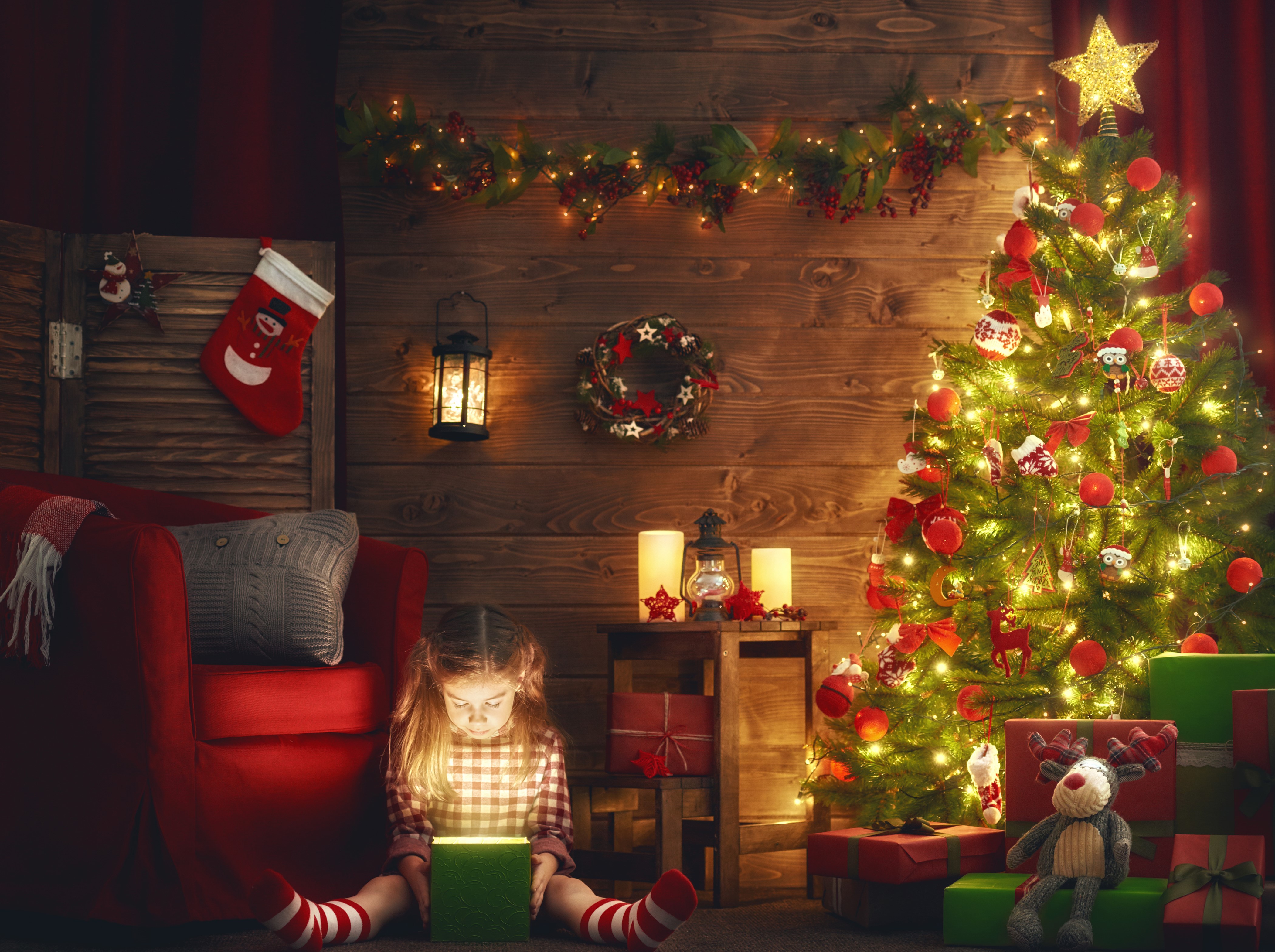 Girl opening a glowing Christmas gift by the tree HD Wallpaper