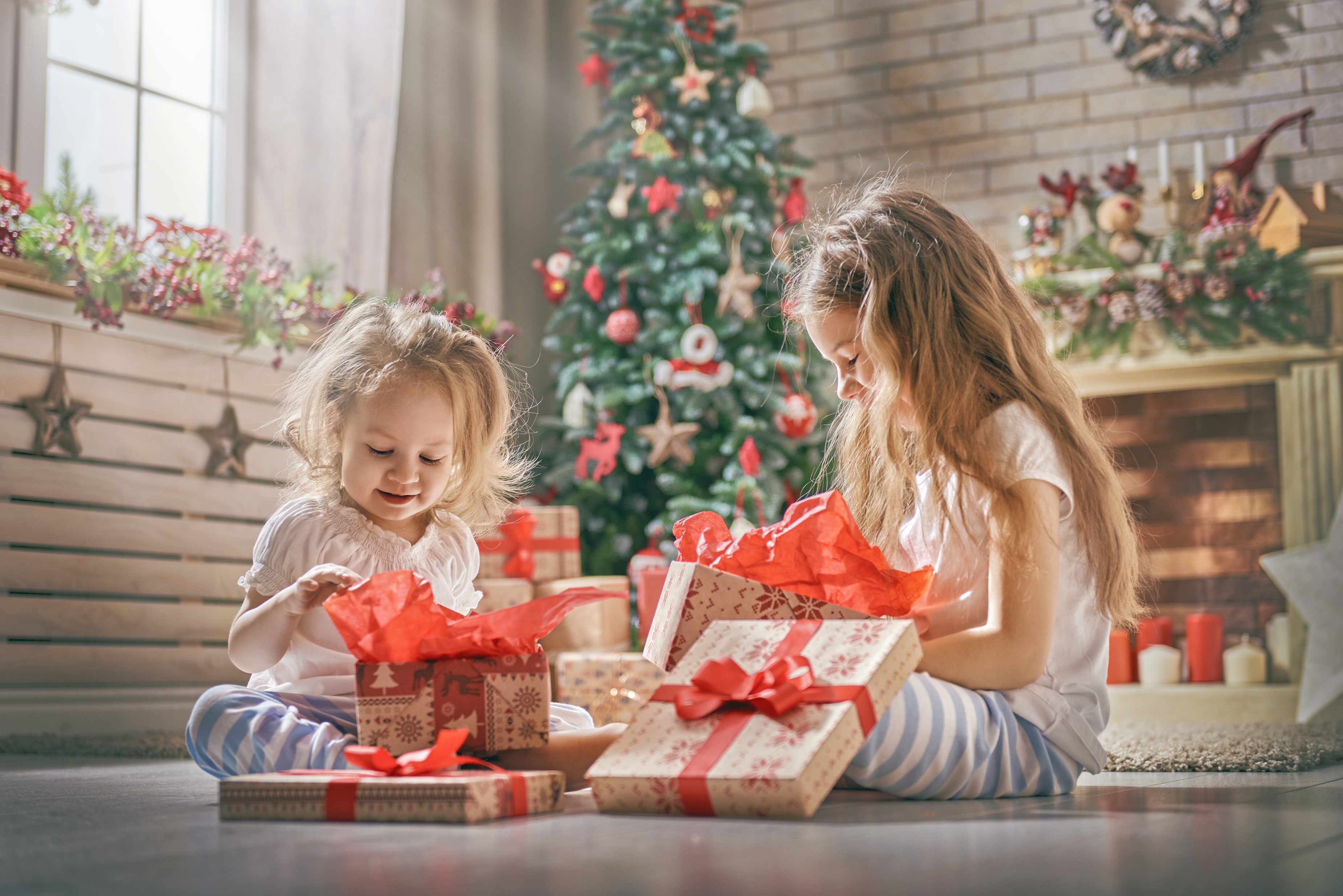 Two young girls opening Christmas gifts HD Wallpaper