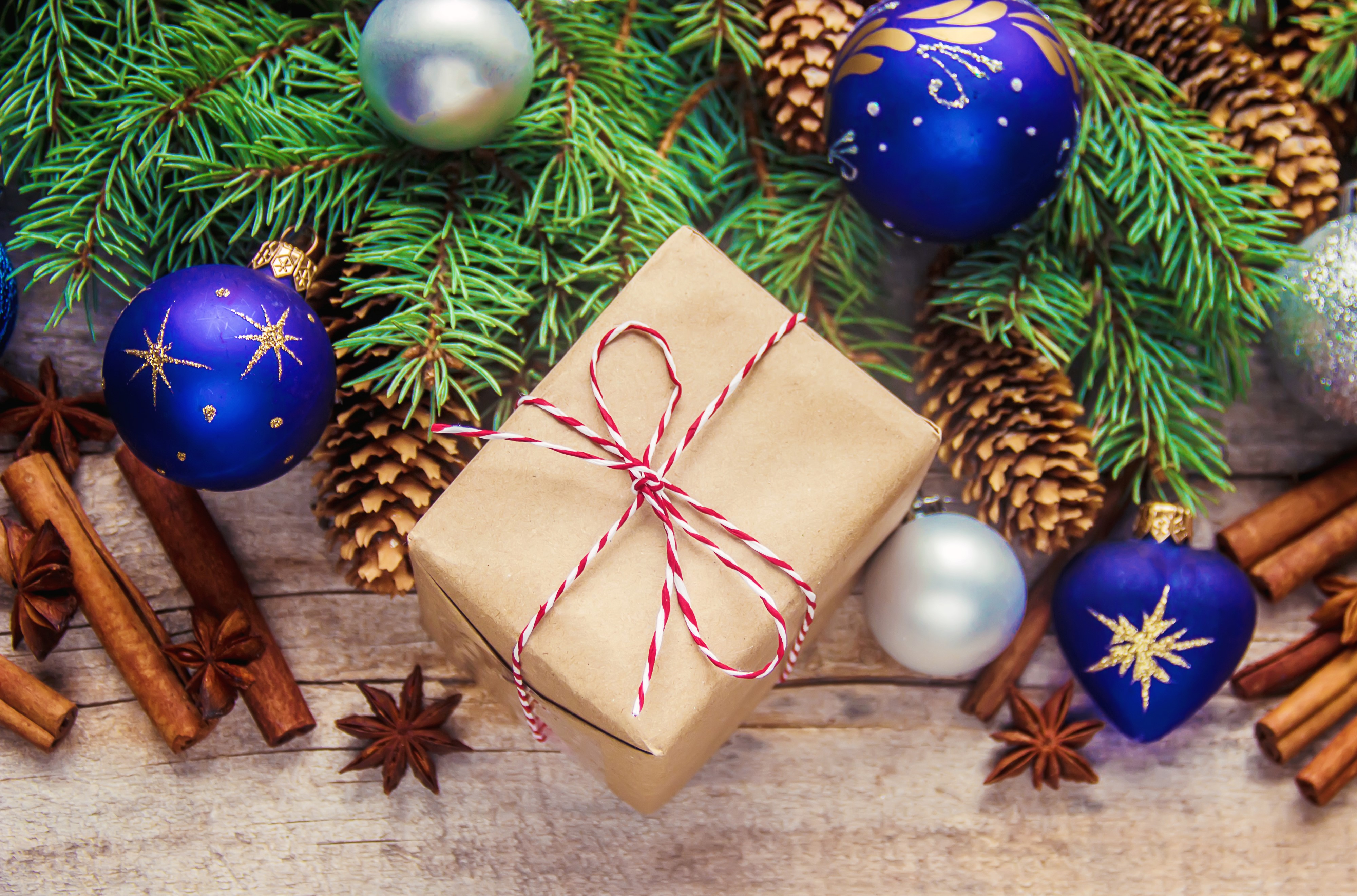 Christmas gift with ornaments, pine cones, and spices HD Wallpaper