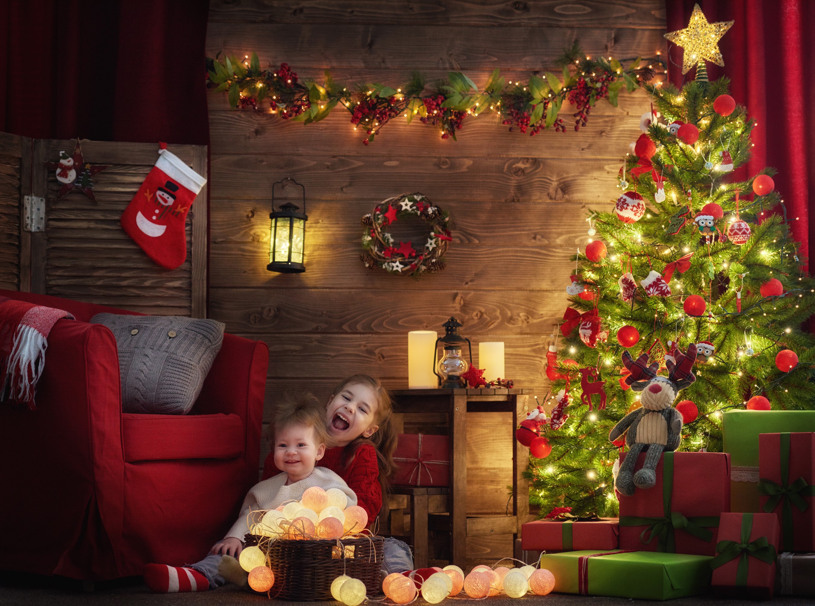 Two young girls by a Christmas tree with gifts HD Wallpaper