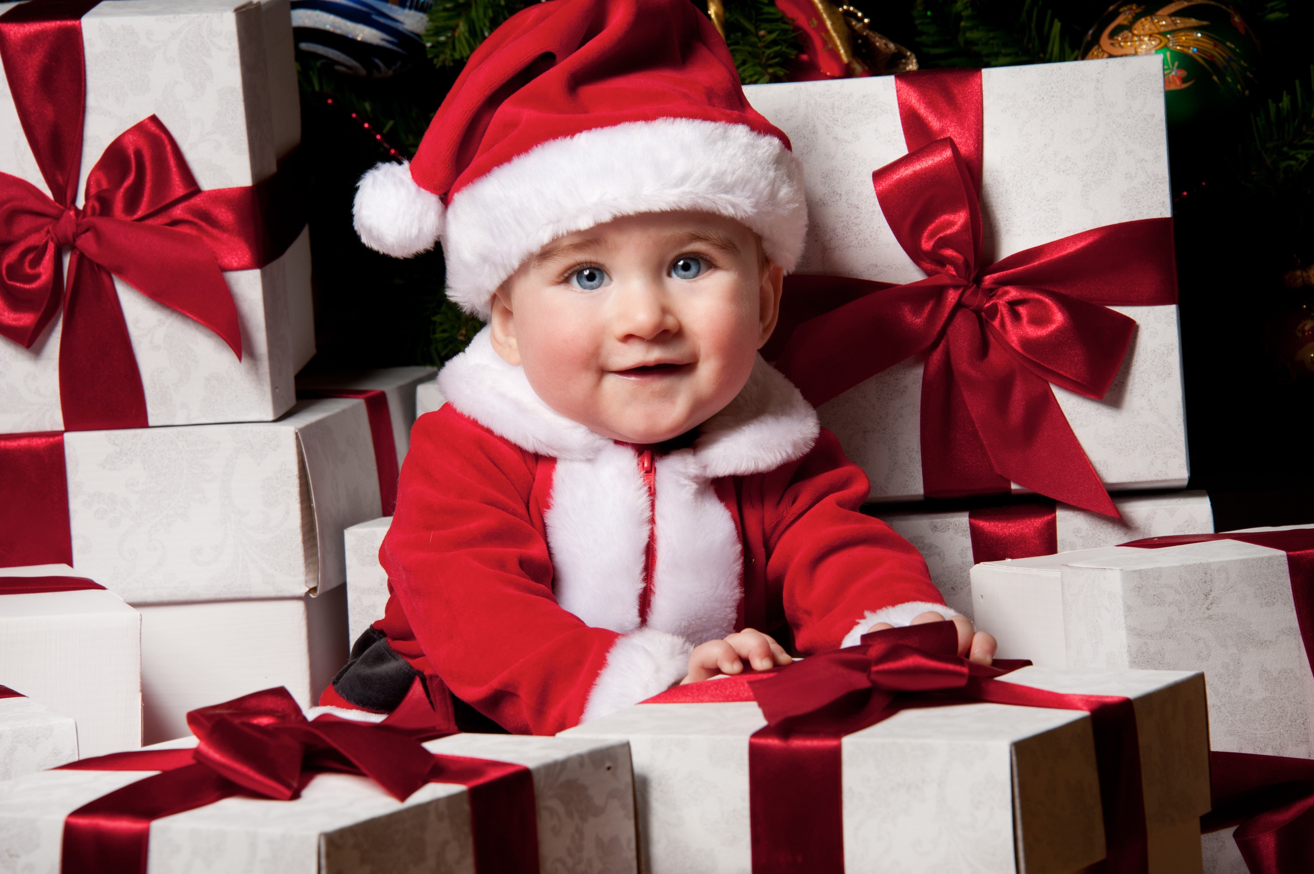 Baby in Santa costume surrounded by Christmas gifts HD Wallpaper