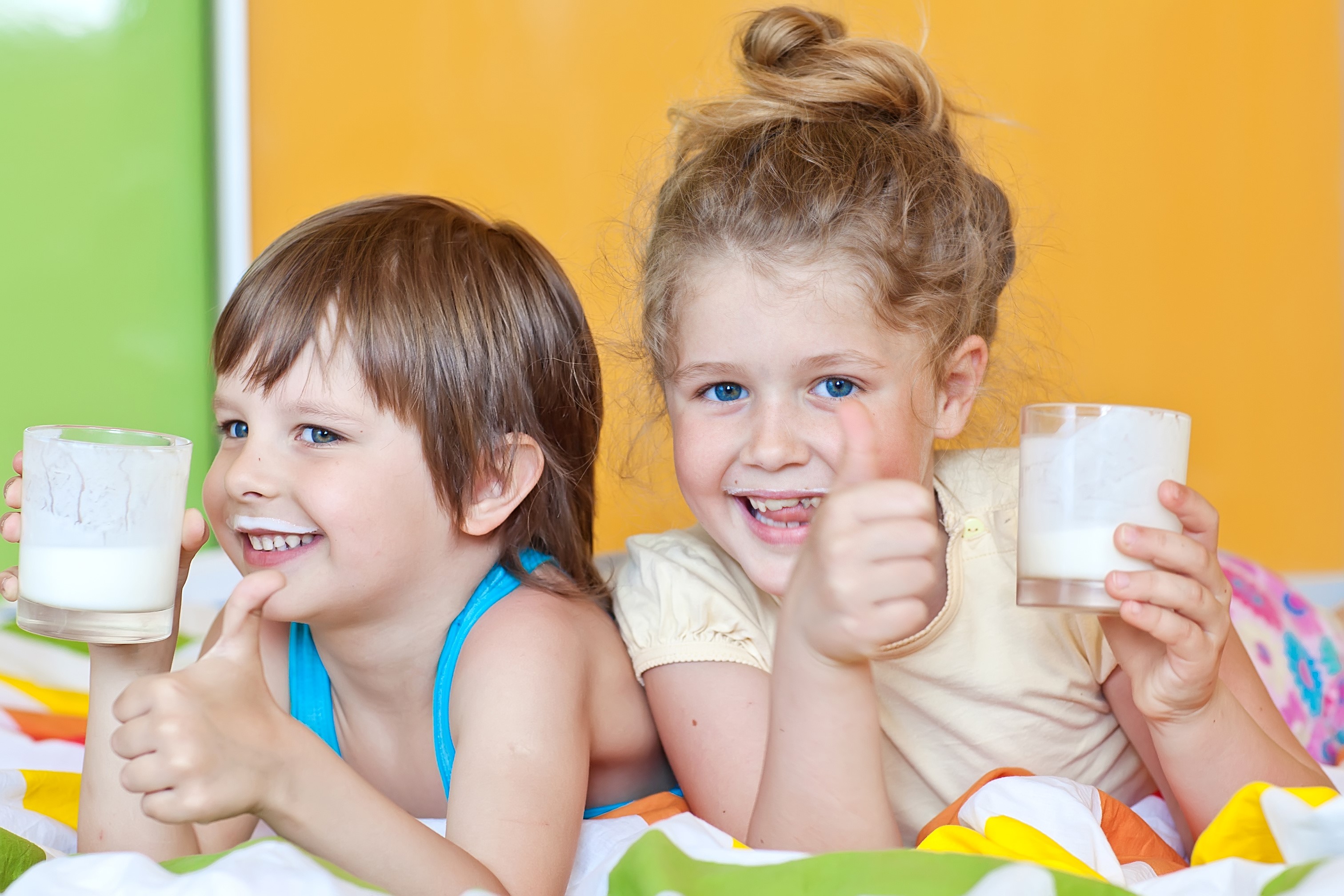 Two children with glasses of milk giving thumbs up HD Wallpaper