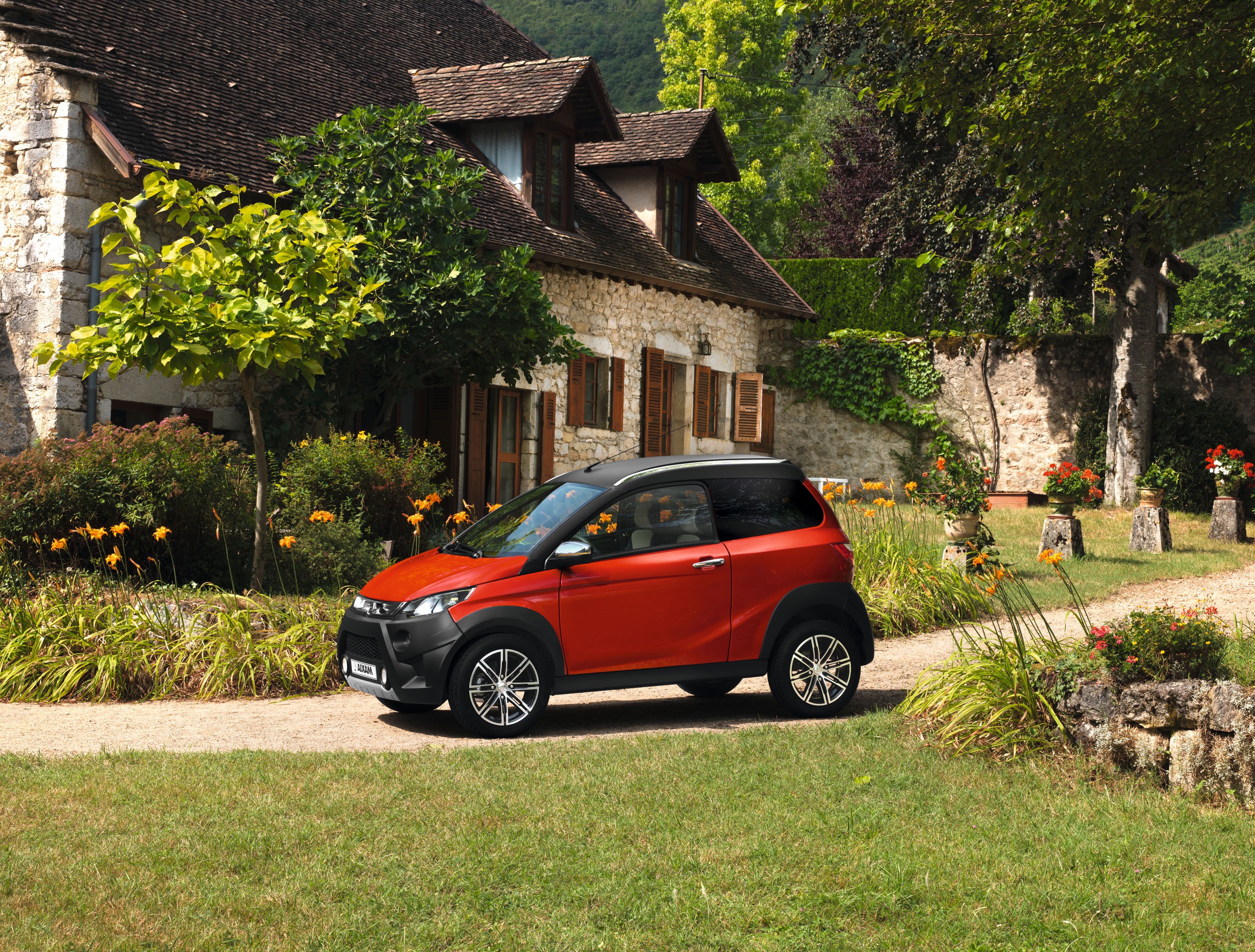 Aixam Crossline Premium car in front of a stone house HD Wallpaper