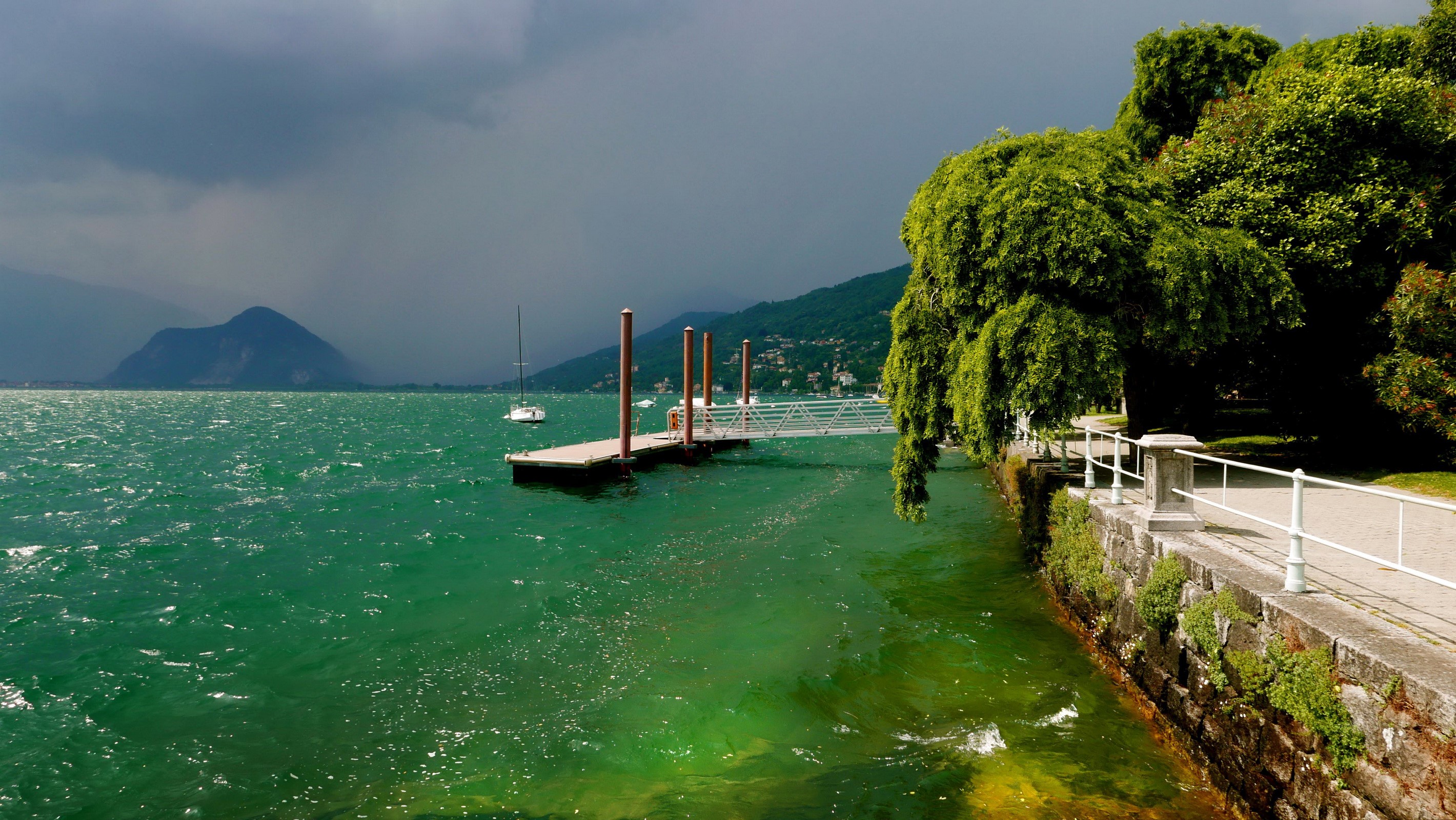 Dock on a lake with a mountain in the background HD Wallpaper