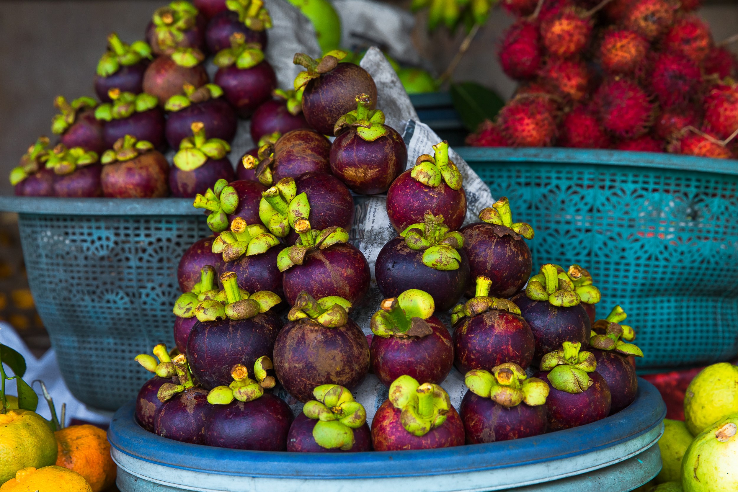 Pile of fresh mangosteens in a basket HD Wallpaper