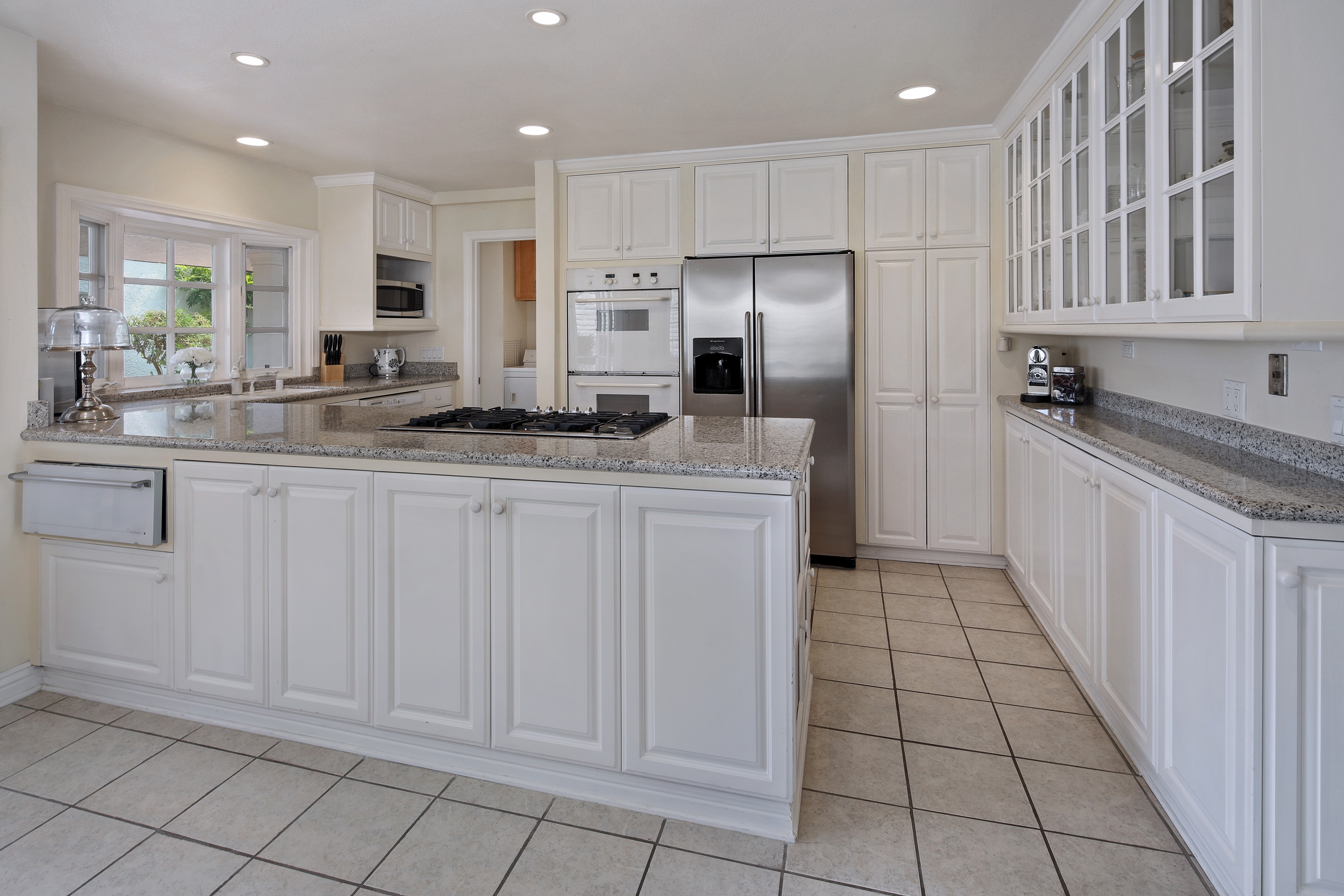 Kitchen with white cabinets and granite countertops HD Wallpaper