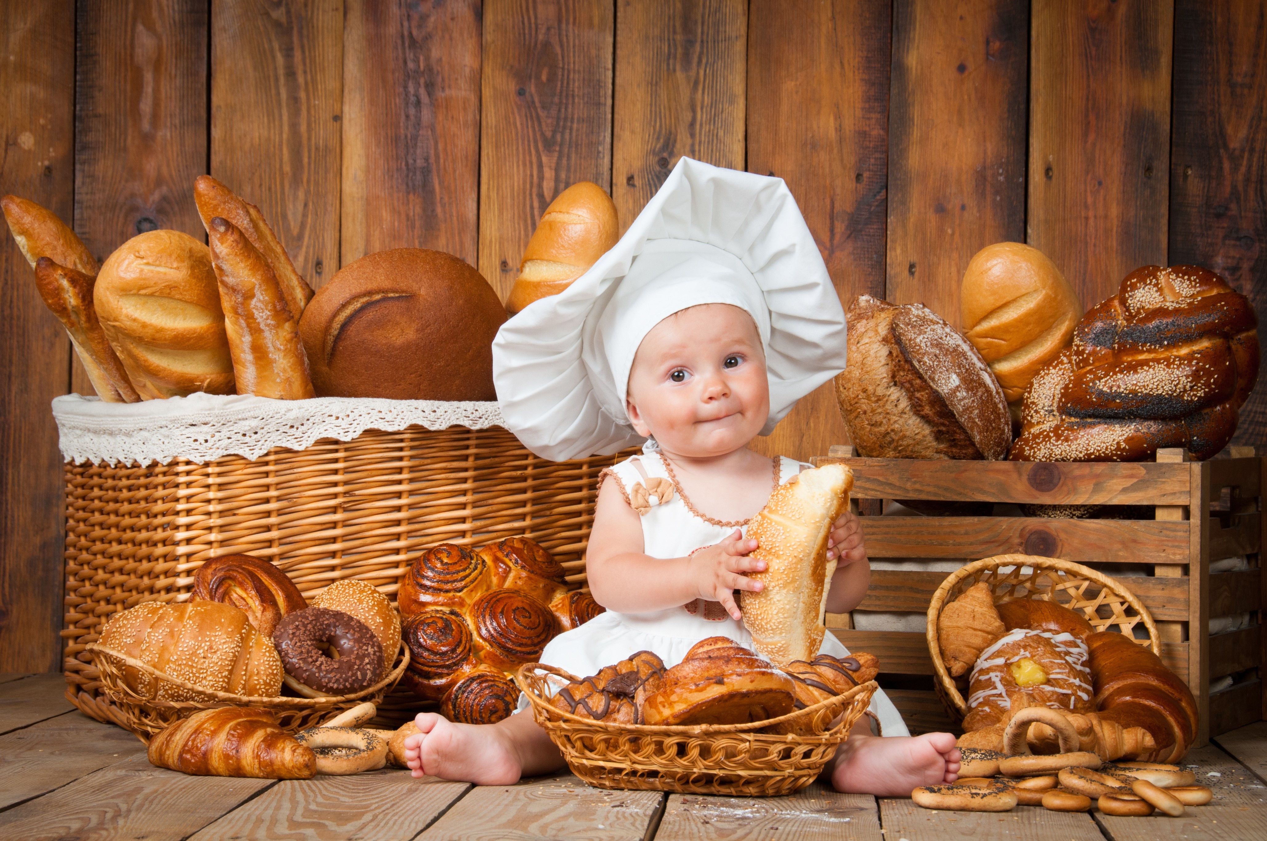 Baby in chef hat with bread and pastries HD Wallpaper