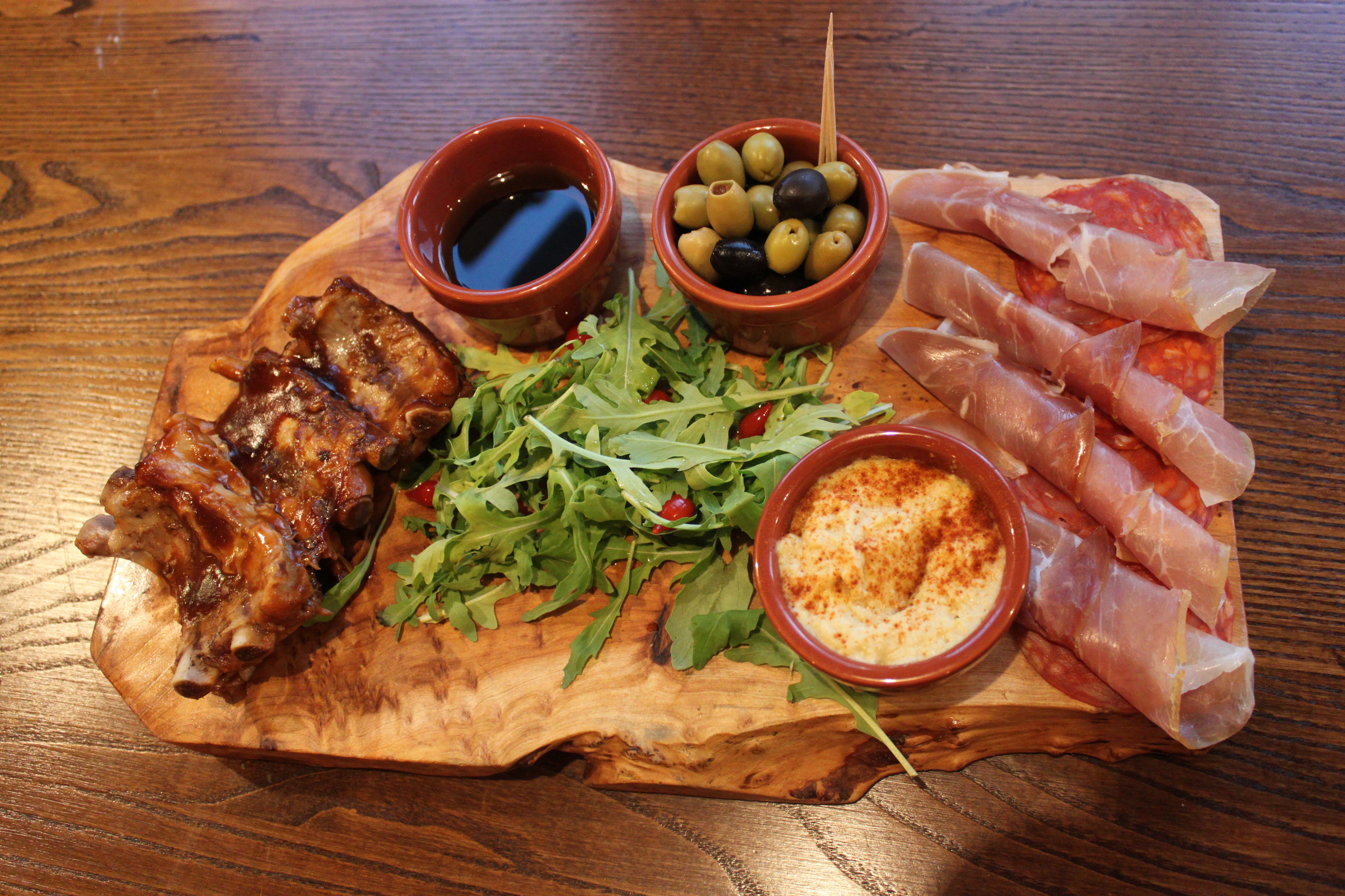 Charcuterie board with ribs, ham, olives, and dip HD Wallpaper