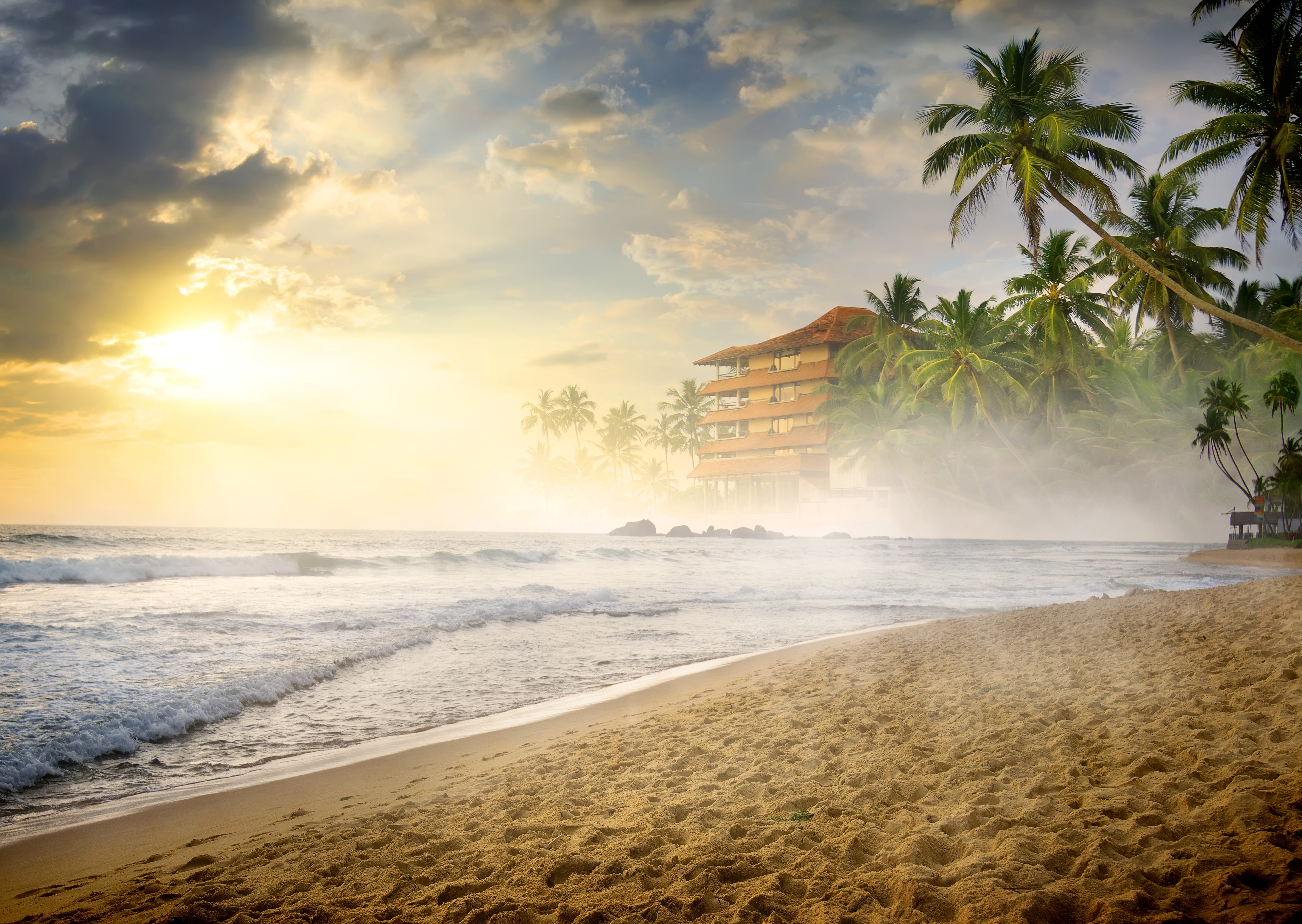 Tropical beach with hotel and palm trees at sunset HD Wallpaper