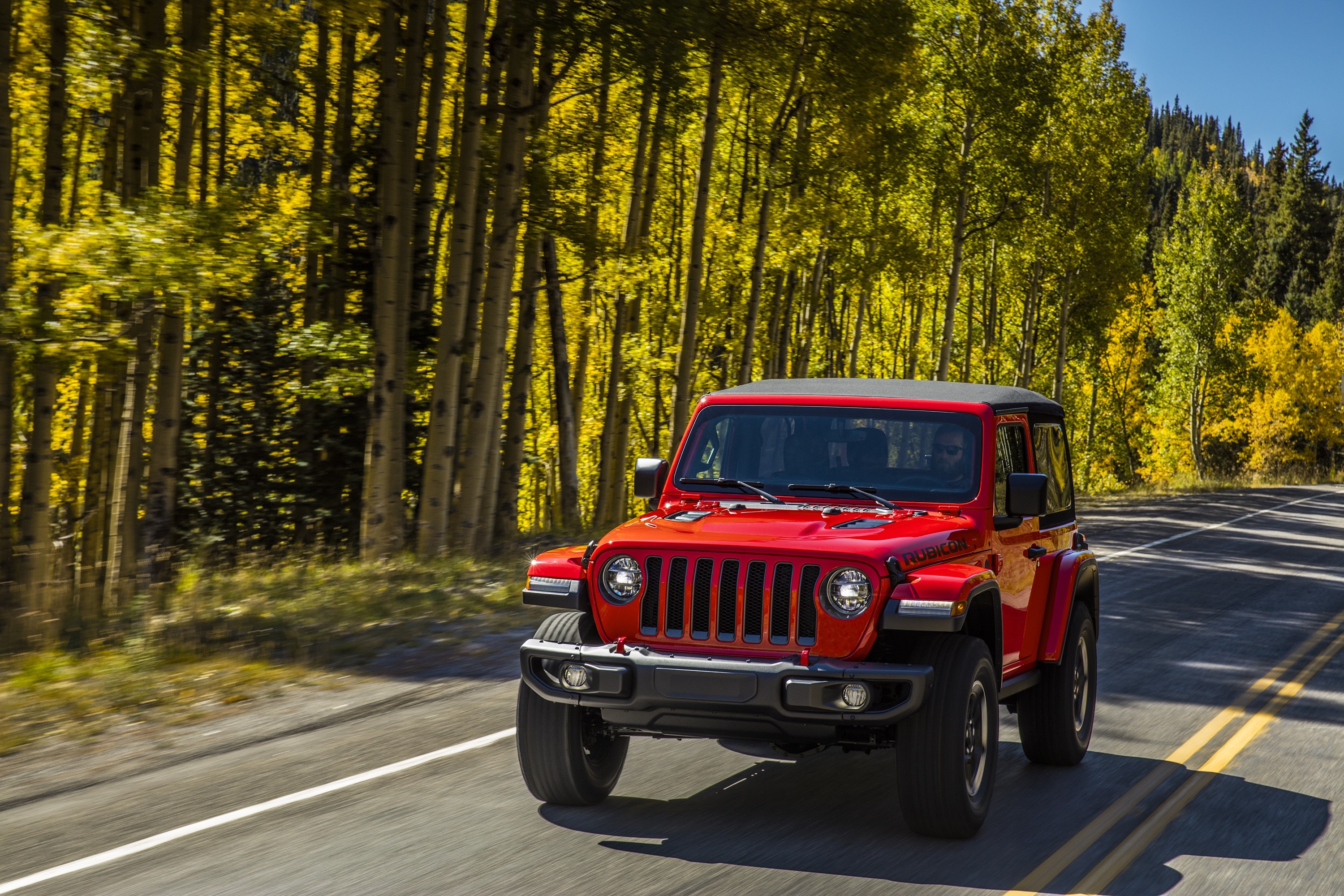 Red Jeep Wrangler Rubicon driving on a road HD Wallpaper