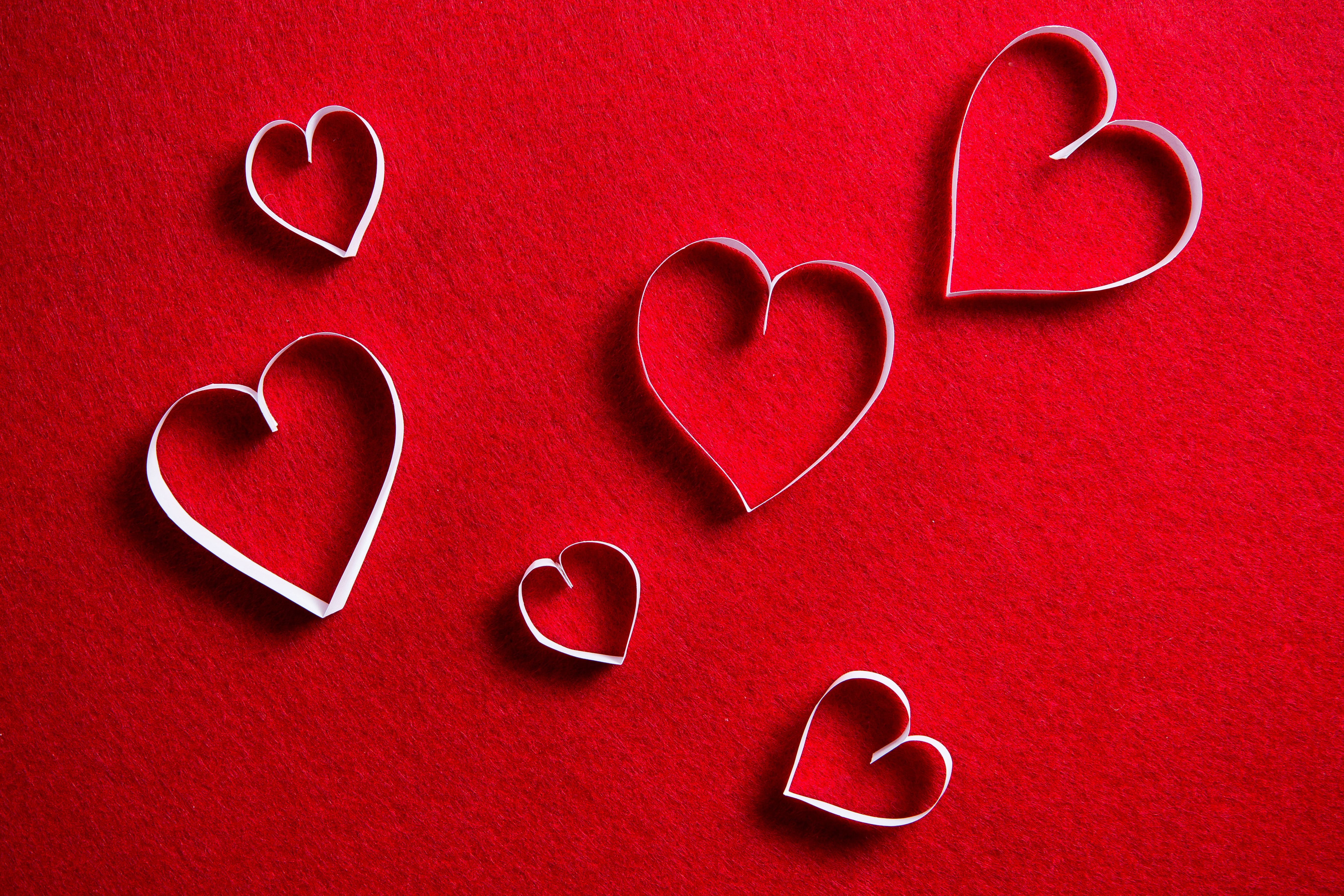 White paper hearts on red background HD Wallpaper