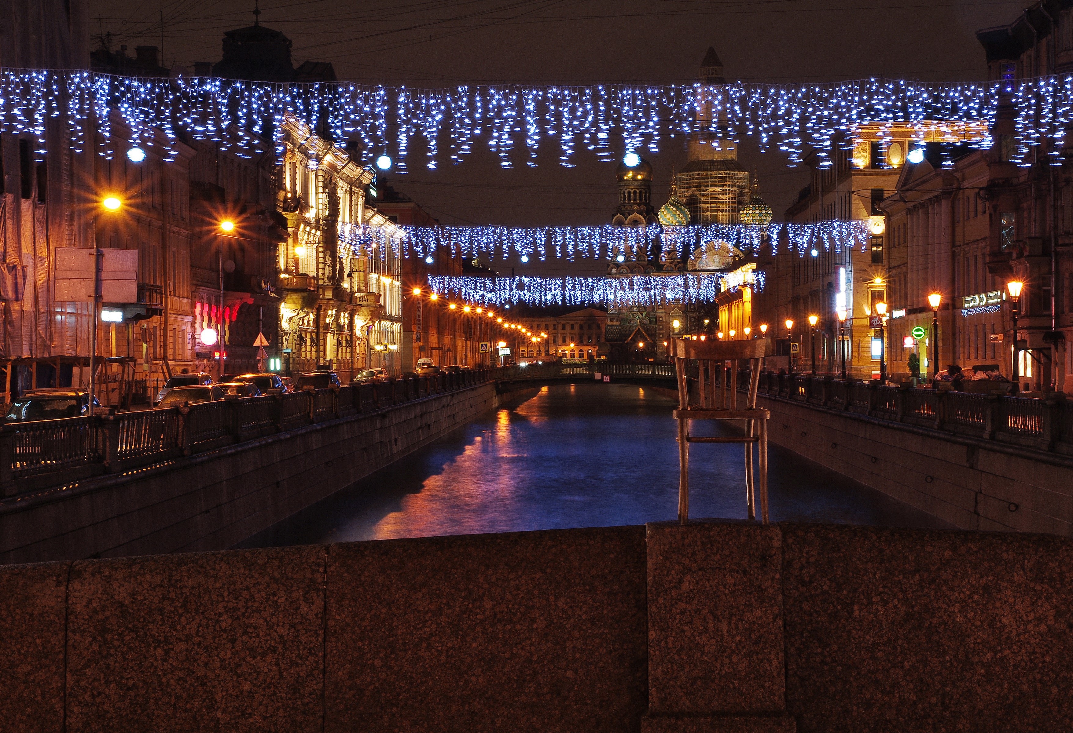 St. Petersburg canal at night with fairy lights and a chair HD Wallpaper