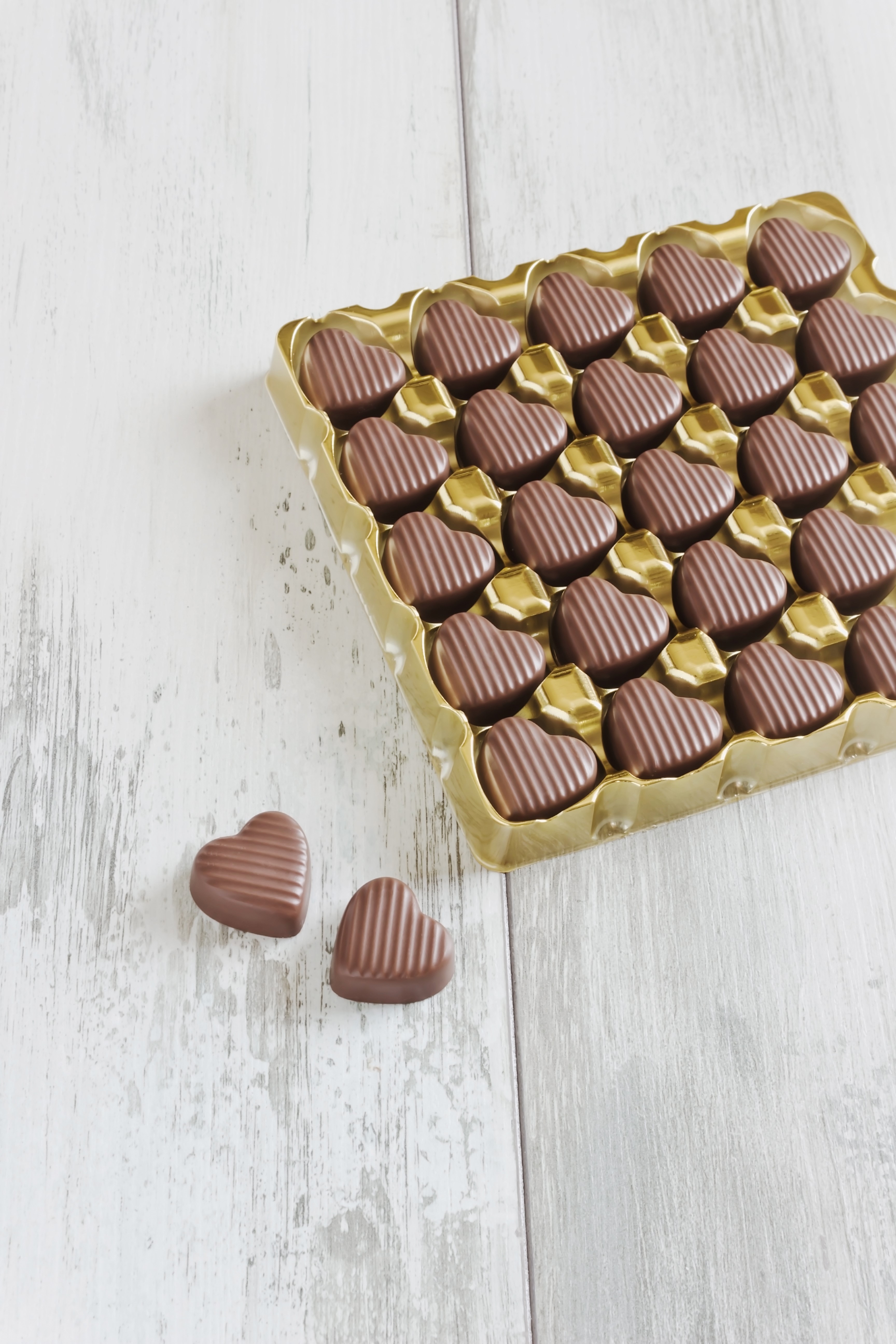 Heart-shaped chocolates in a golden tray HD Phone Wallpaper