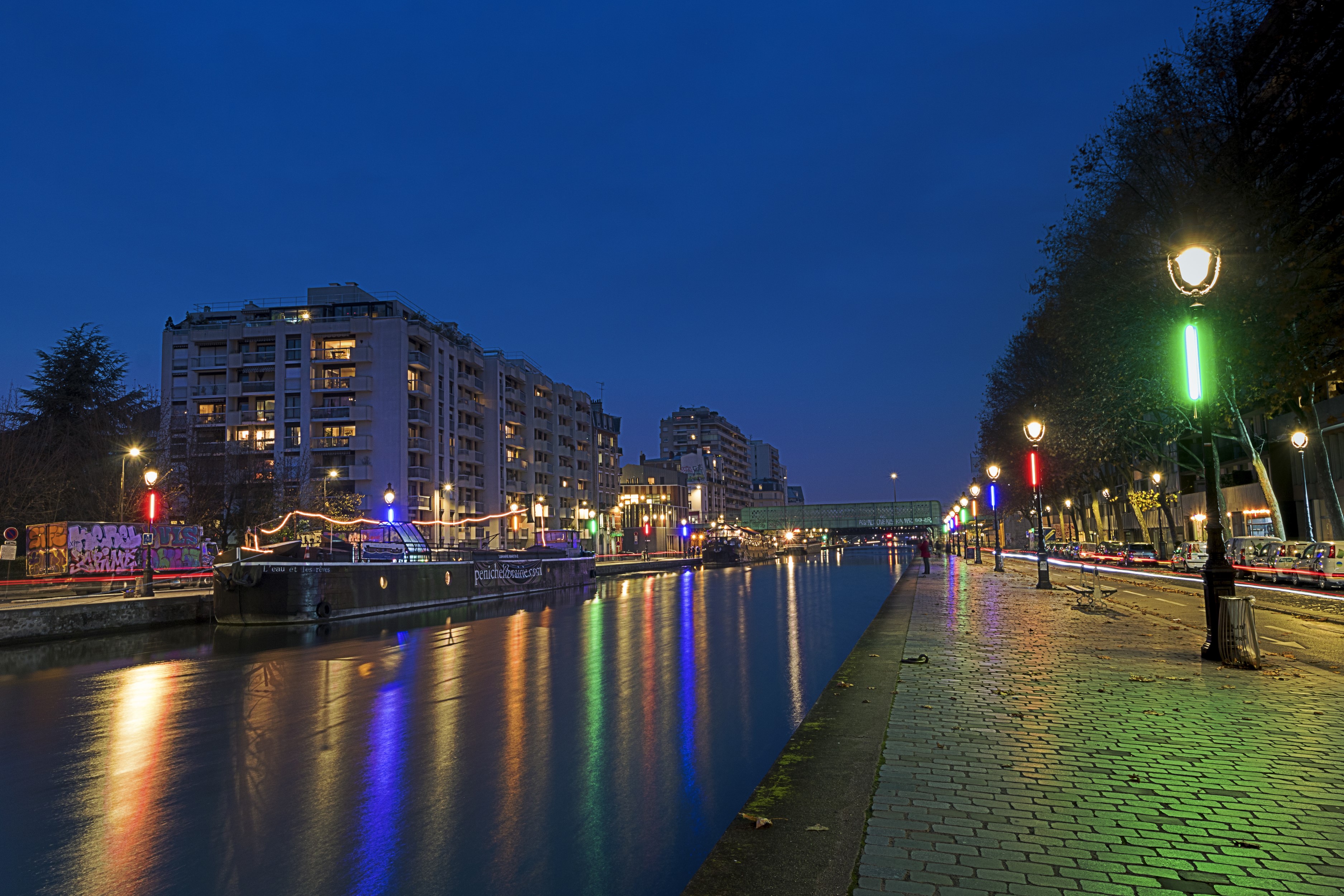 Paris canal at night with illuminated buildings and streetlights HD Wallpaper