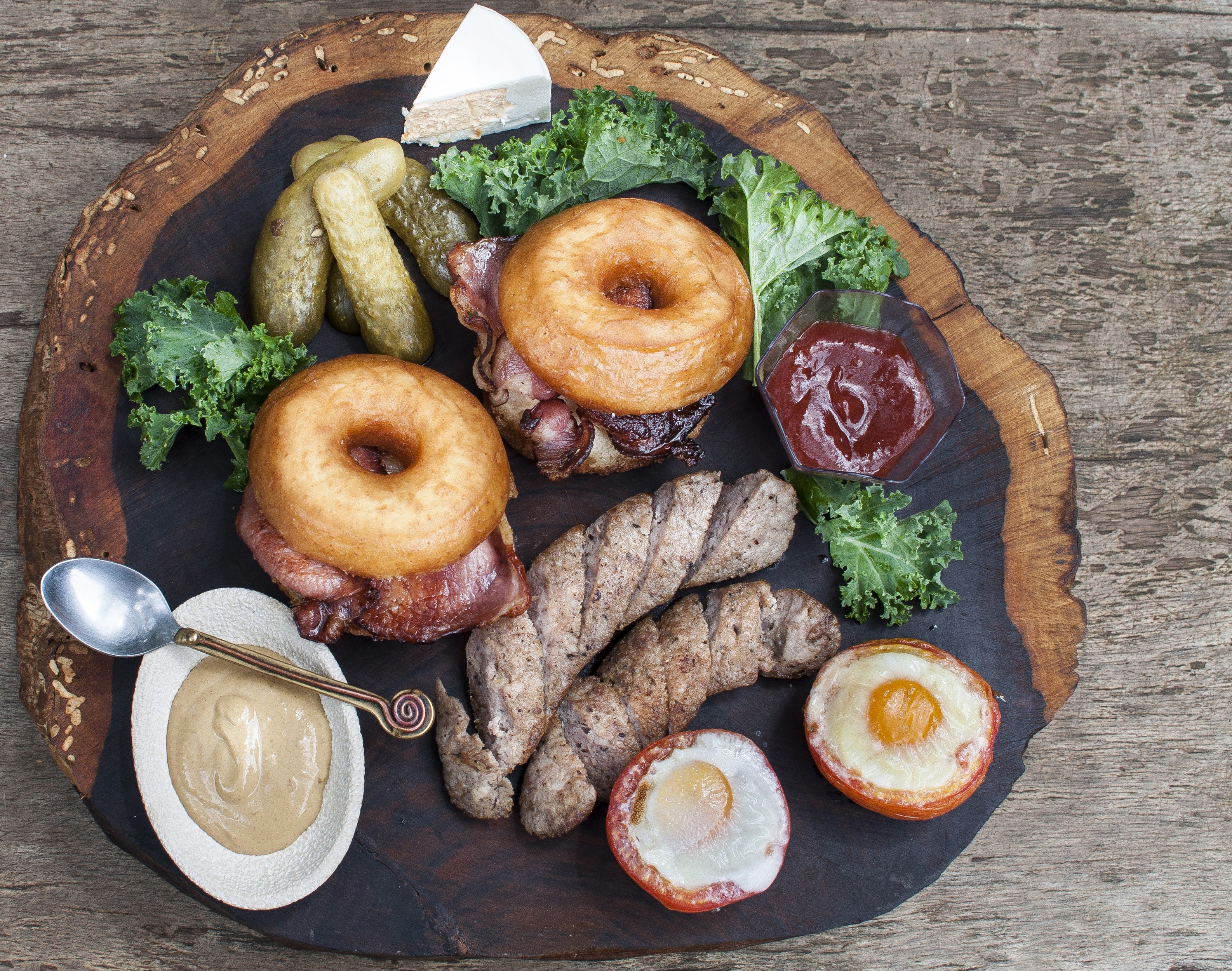 Donut burgers with sausages, pickles, cheese, and fried eggs HD Wallpaper