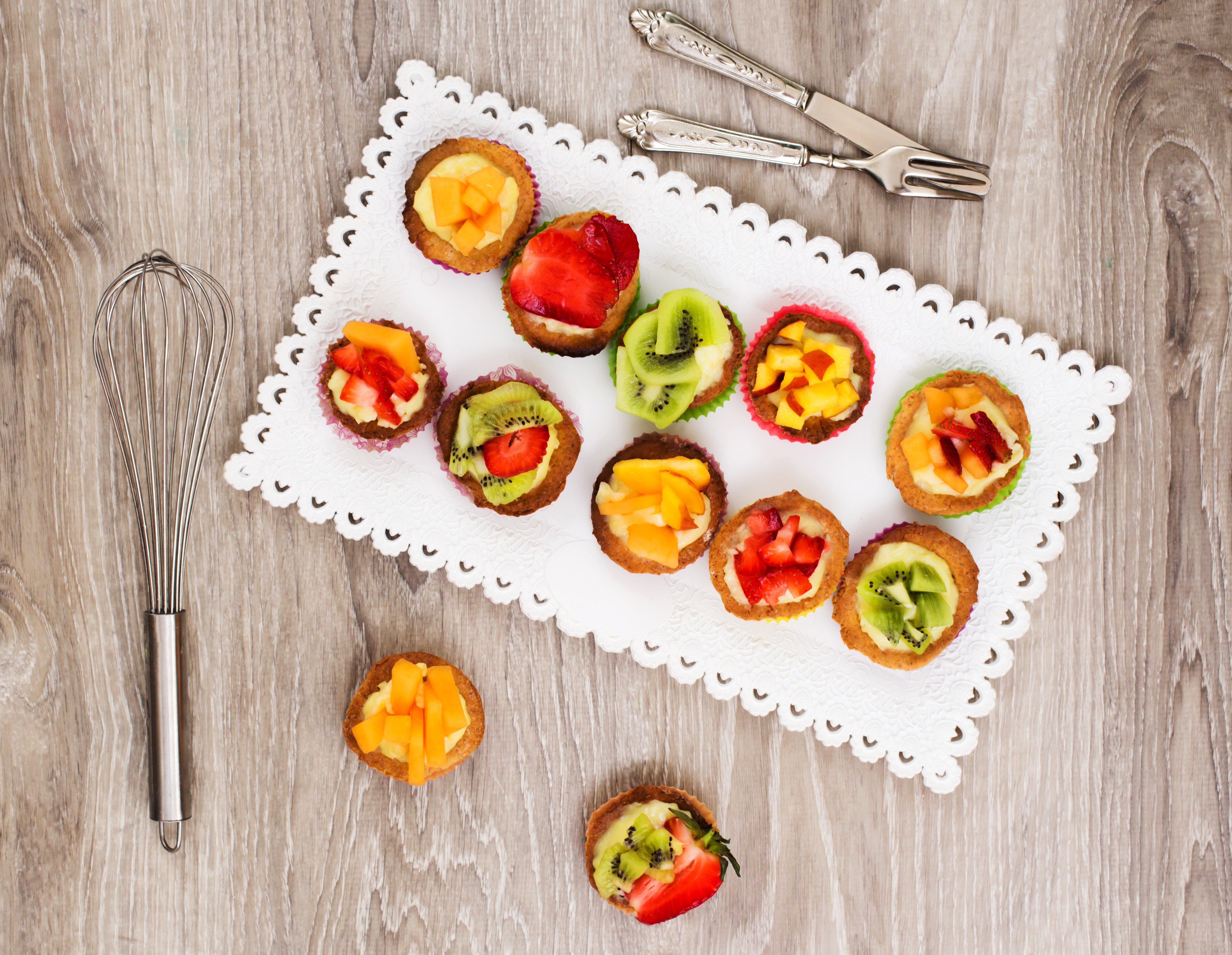 Fruit tarts on a white doily with a whisk HD Wallpaper
