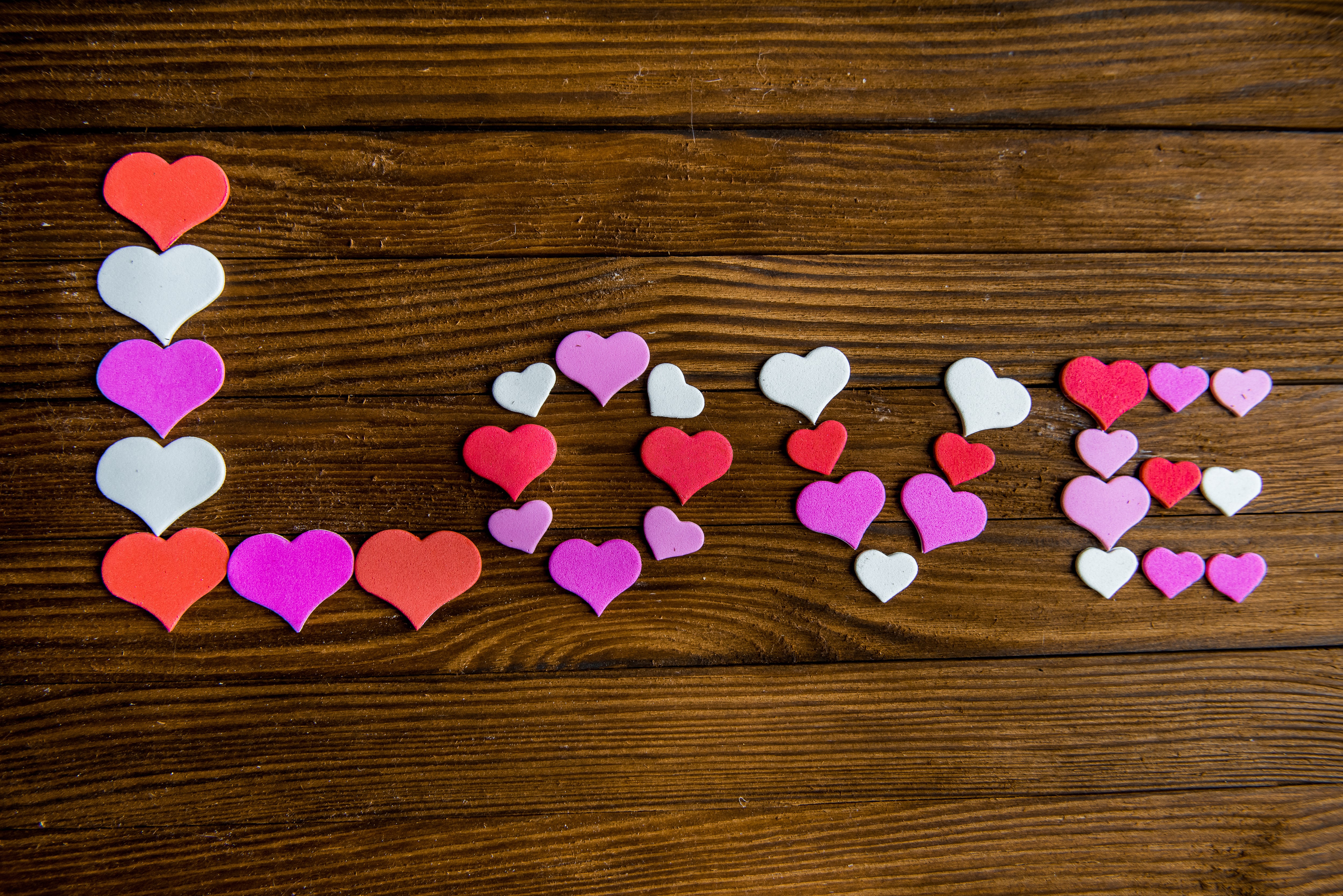 LOVE spelled with heart shapes on wood planks HD Wallpaper