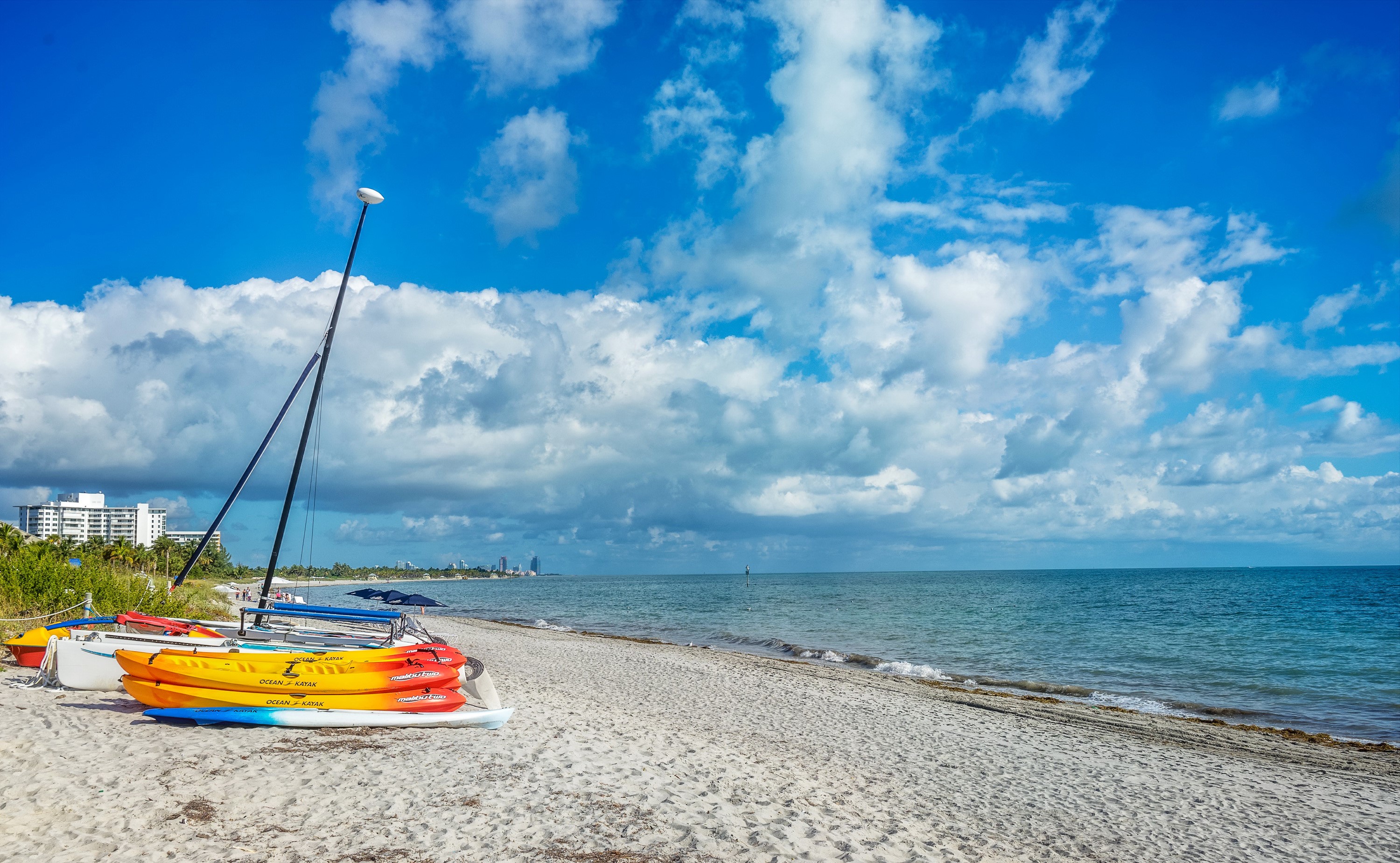 Kayaks and sailboats on a sandy beach in Florida HD Wallpaper