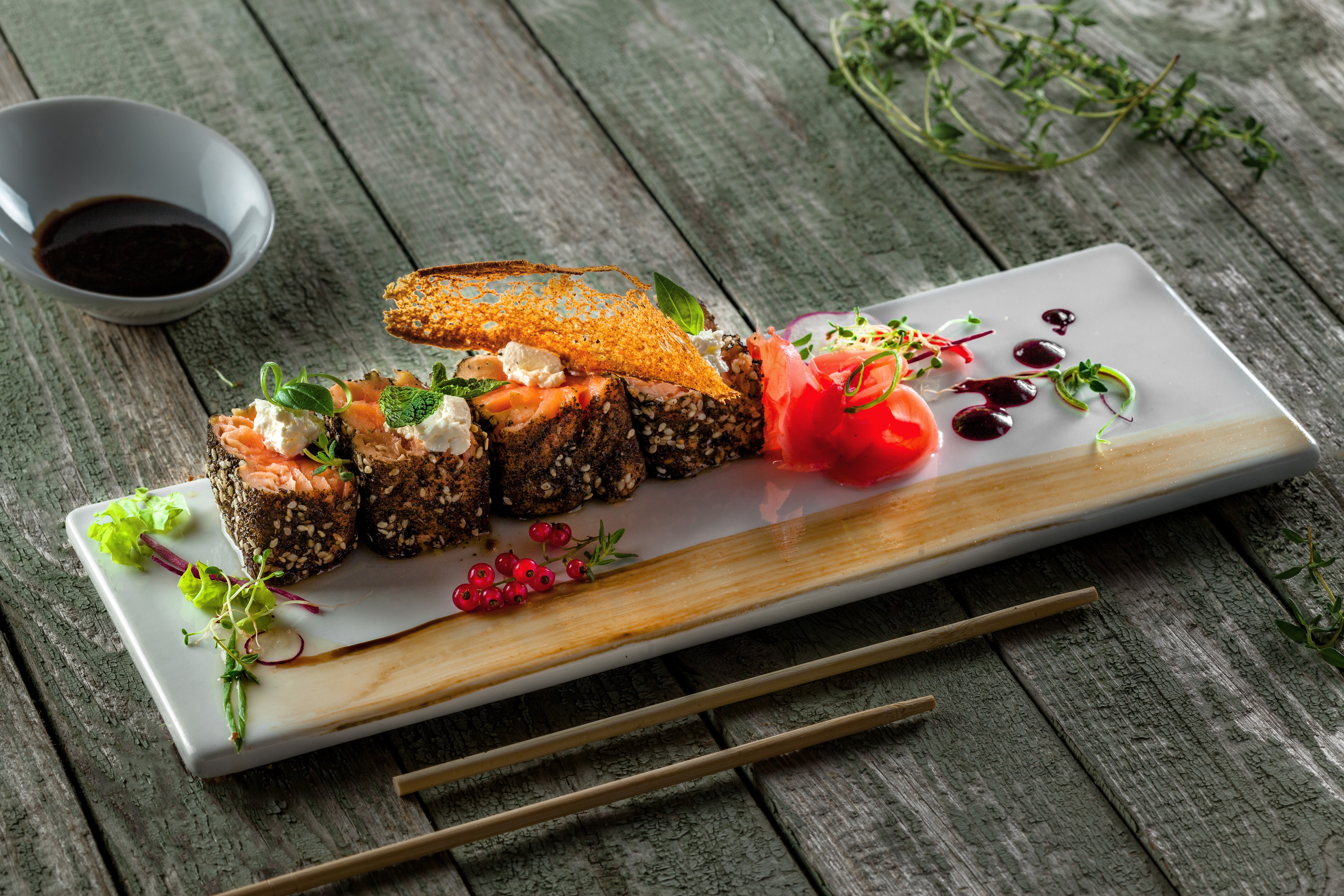 Sushi with salmon, cheese, and currants on a wooden table HD Wallpaper
