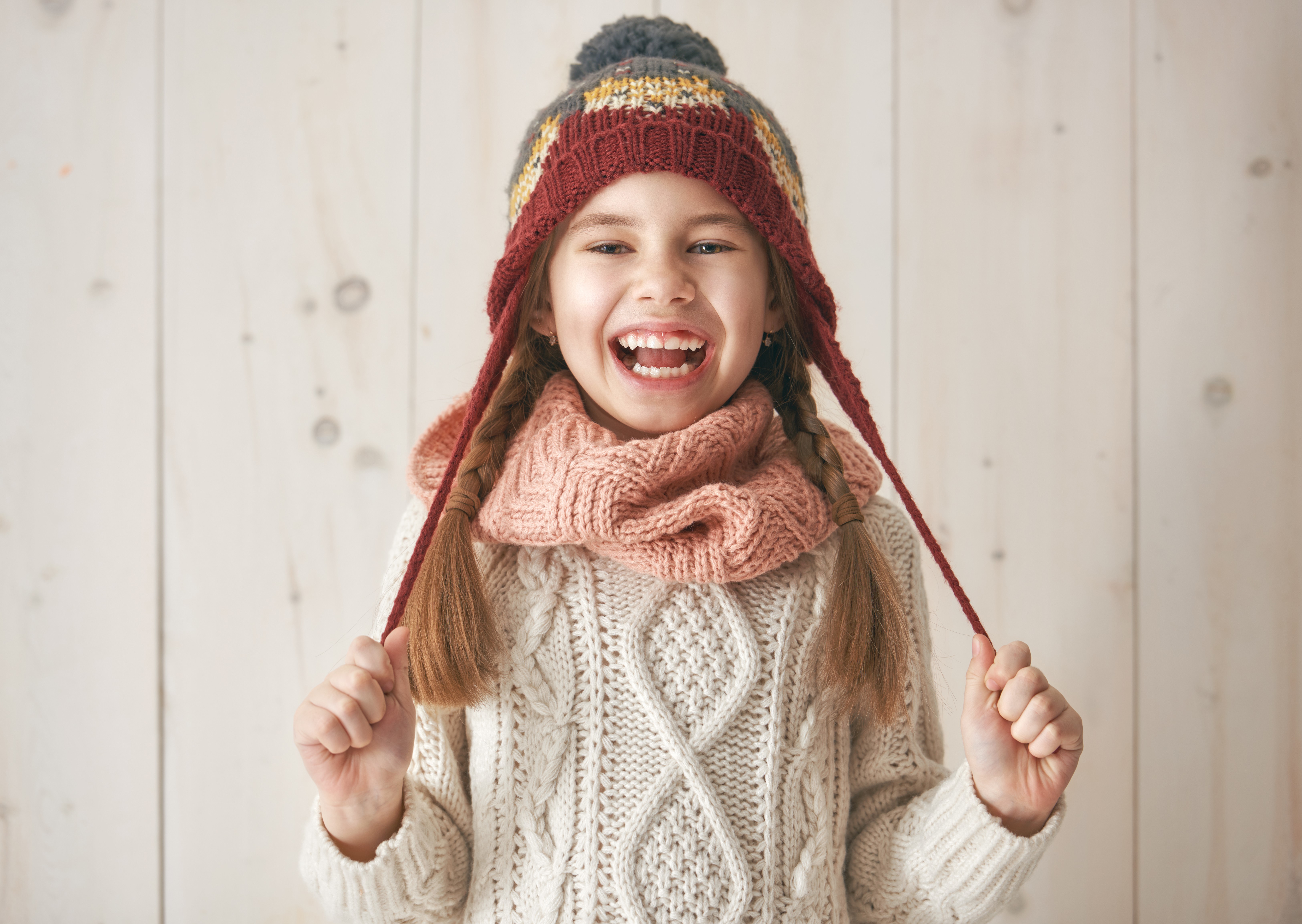 Little girl in winter hat and sweater laughing HD Wallpaper