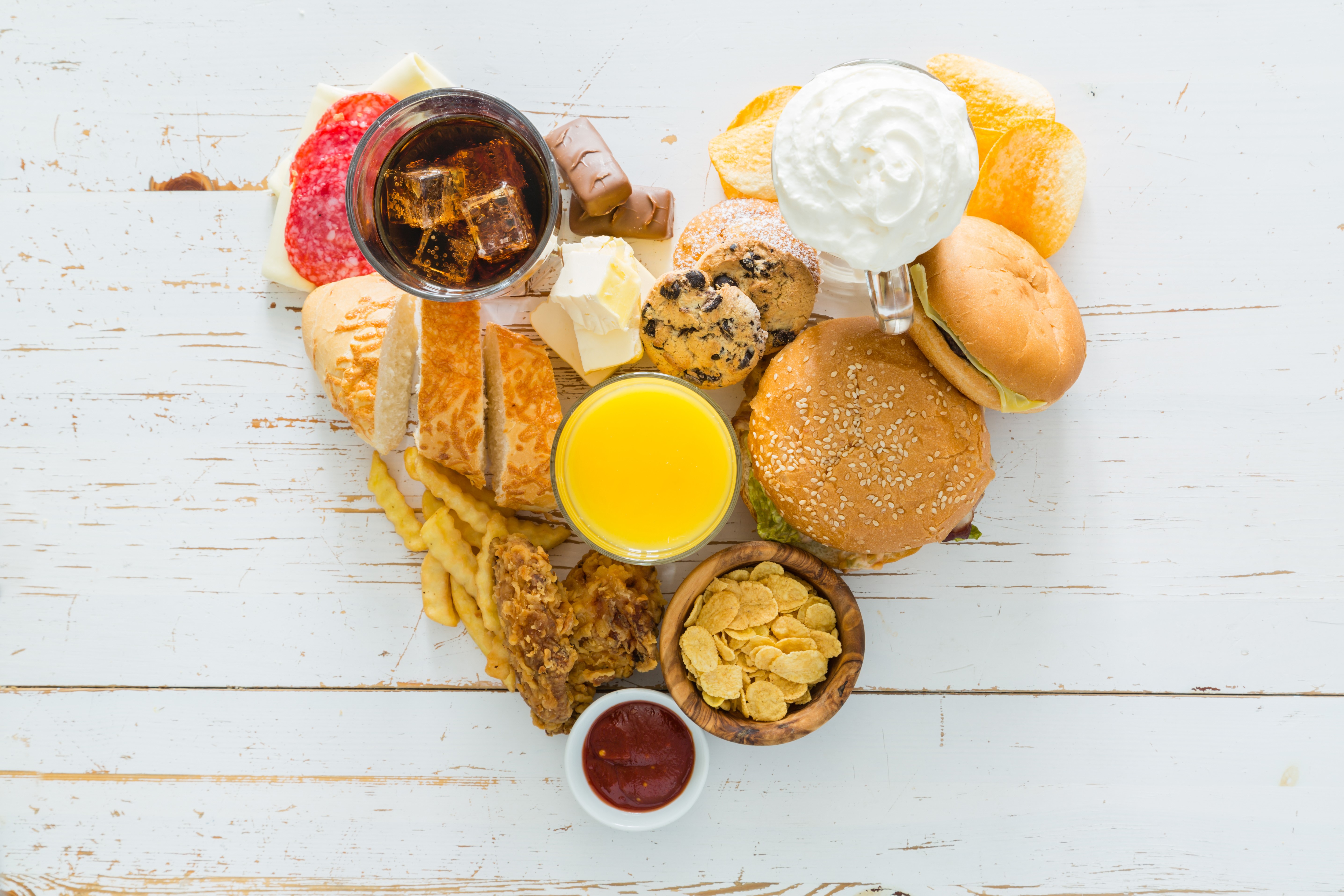 Heart shape of unhealthy food including burgers, fries, and sweets HD Wallpaper