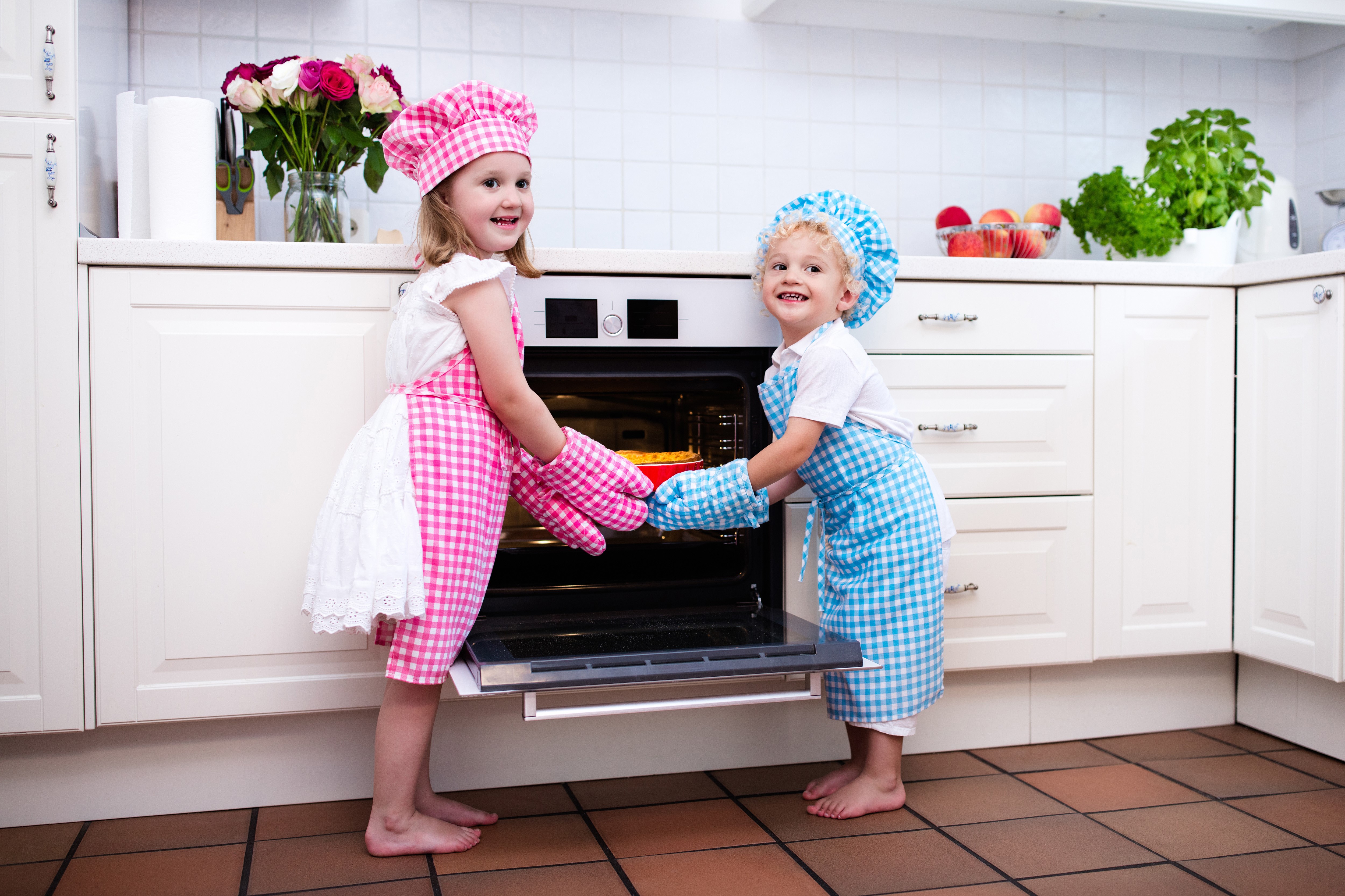 Children in chef uniforms baking in a kitchen HD Wallpaper