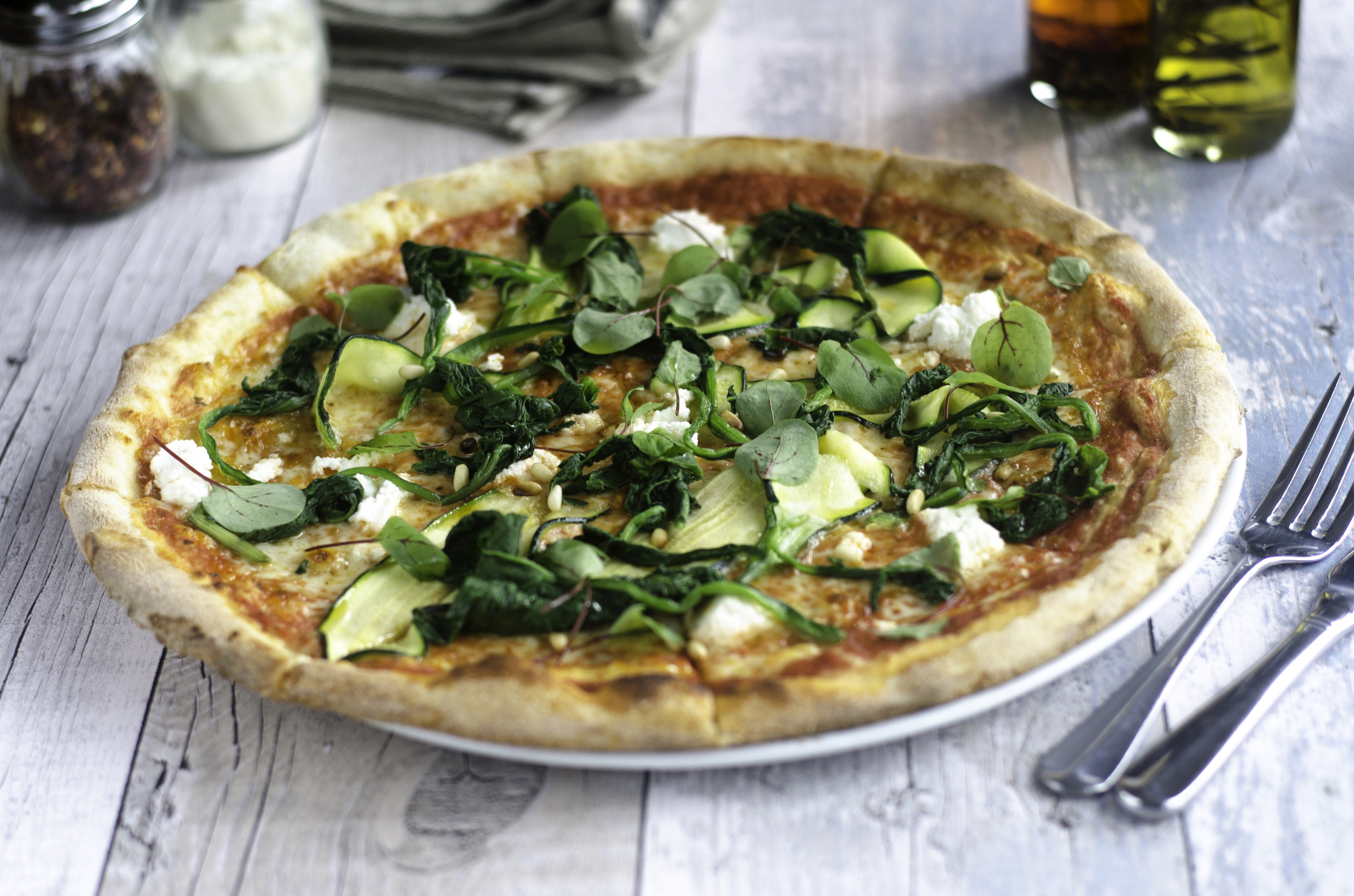 Pizza with vegetables and cheese on a wooden table HD Wallpaper