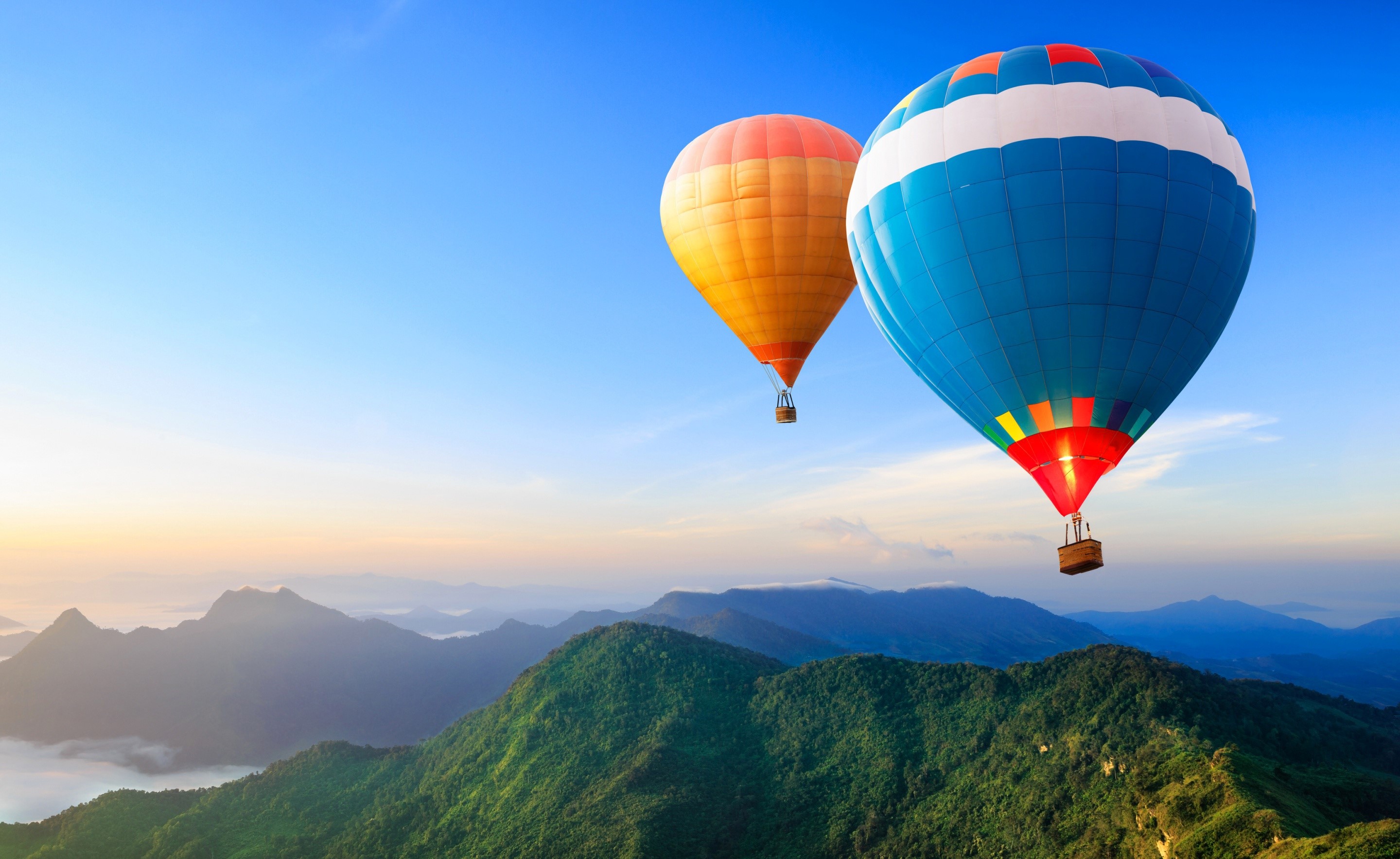 Two hot air balloons flying over mountains HD Wallpaper