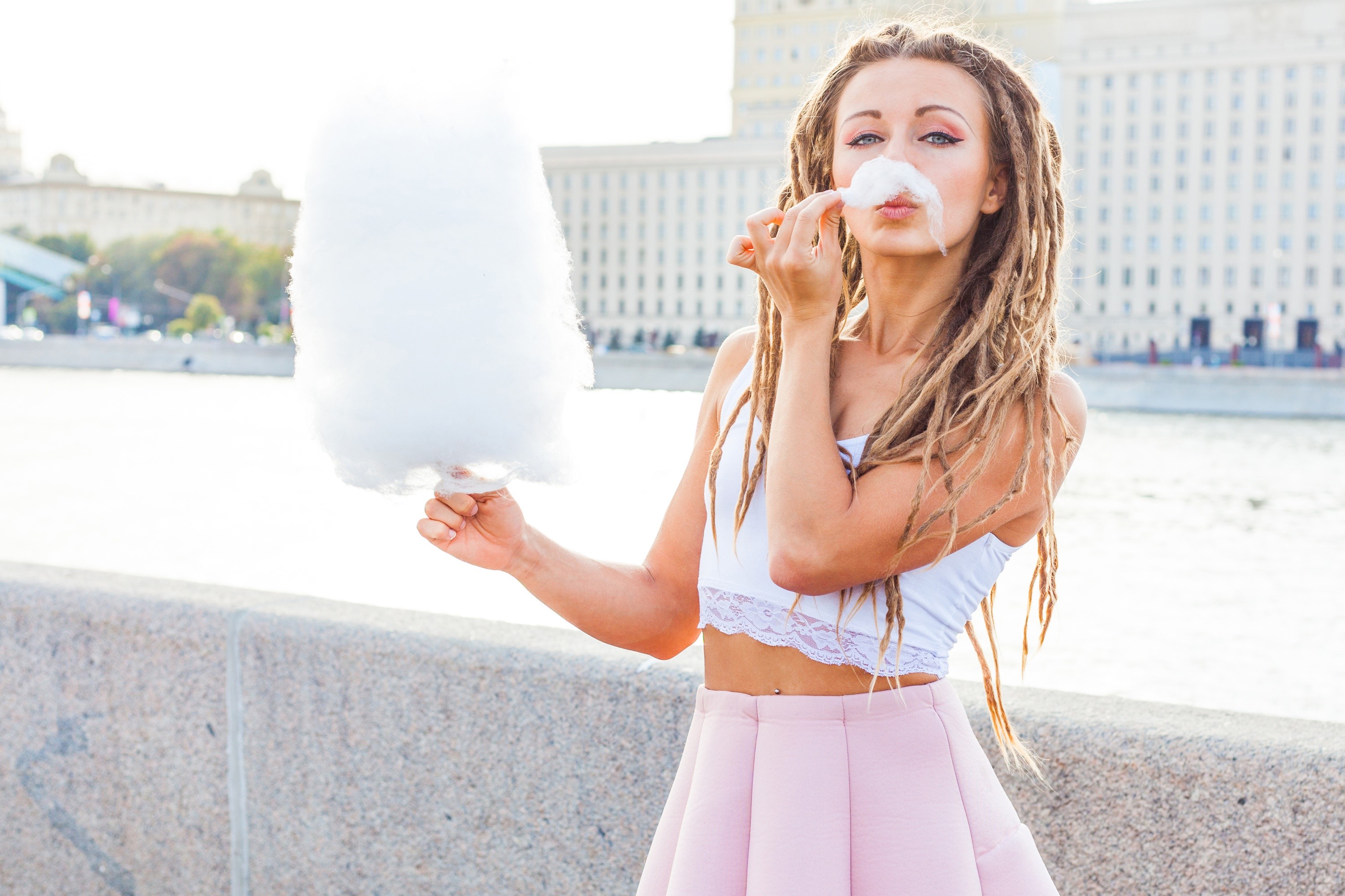 Woman with dreadlocks eating cotton candy HD Wallpaper