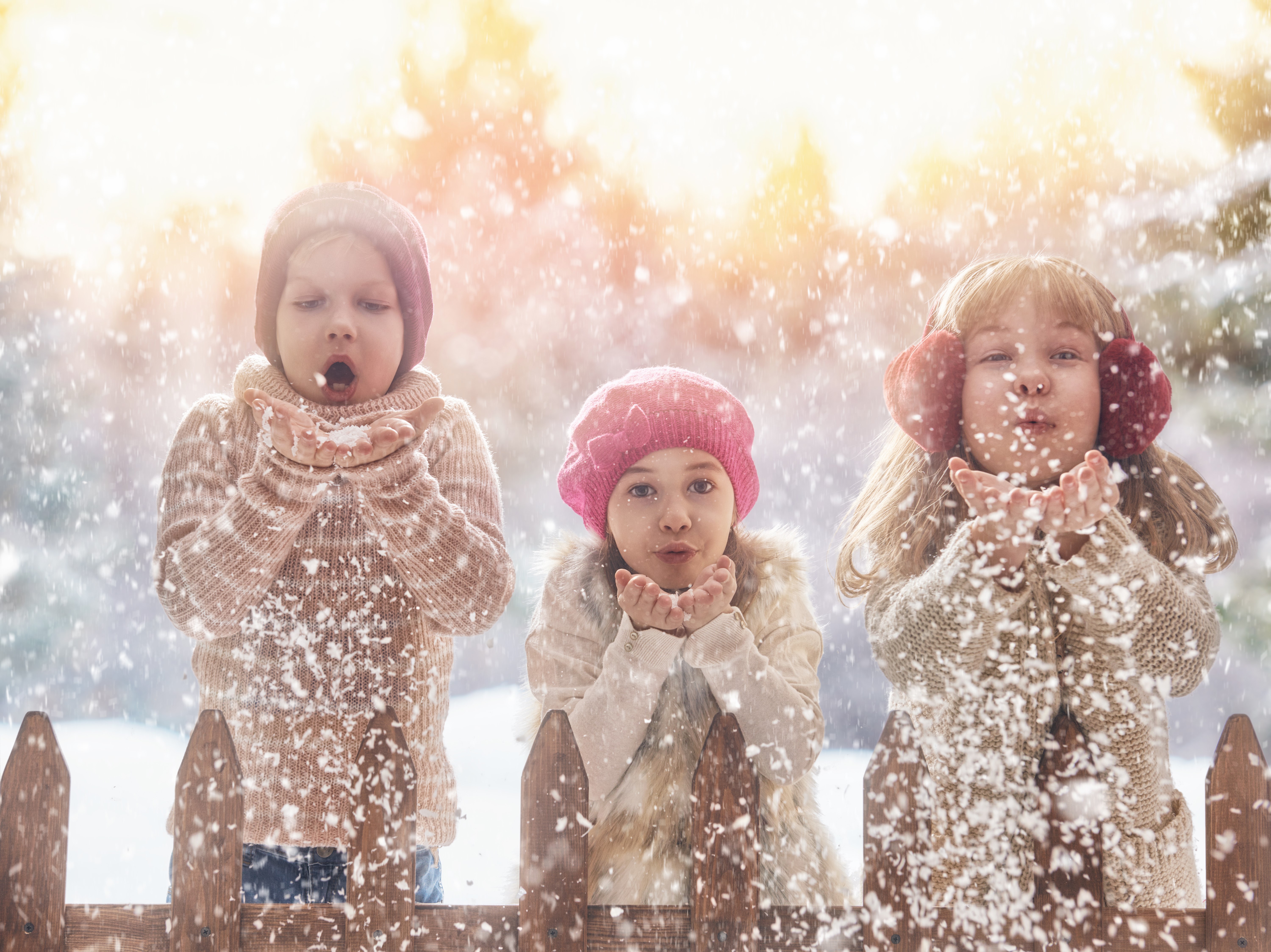 Three little girls blowing snow in winter HD Wallpaper