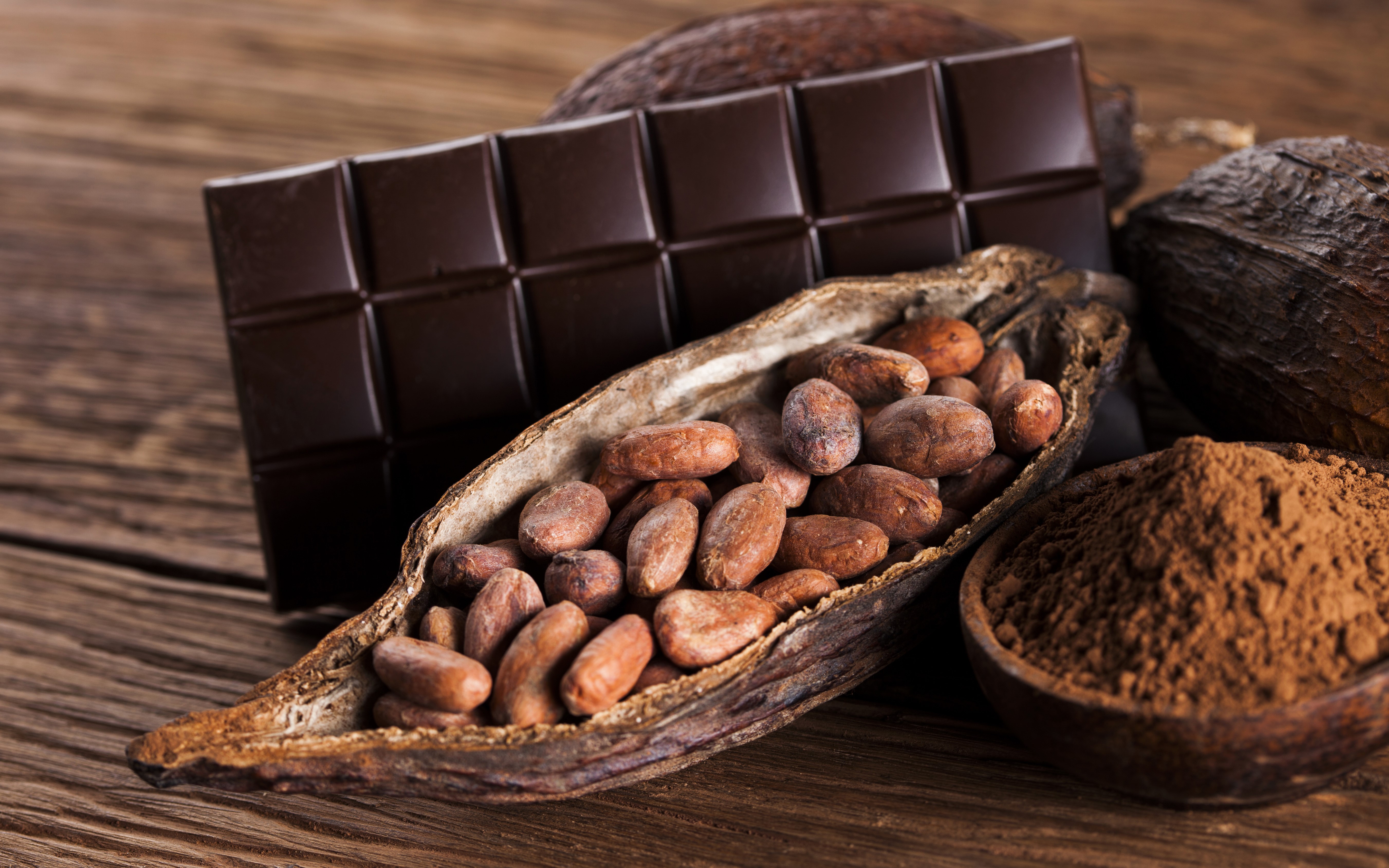 Chocolate bar, cocoa beans, and cocoa powder on wood HD Wallpaper