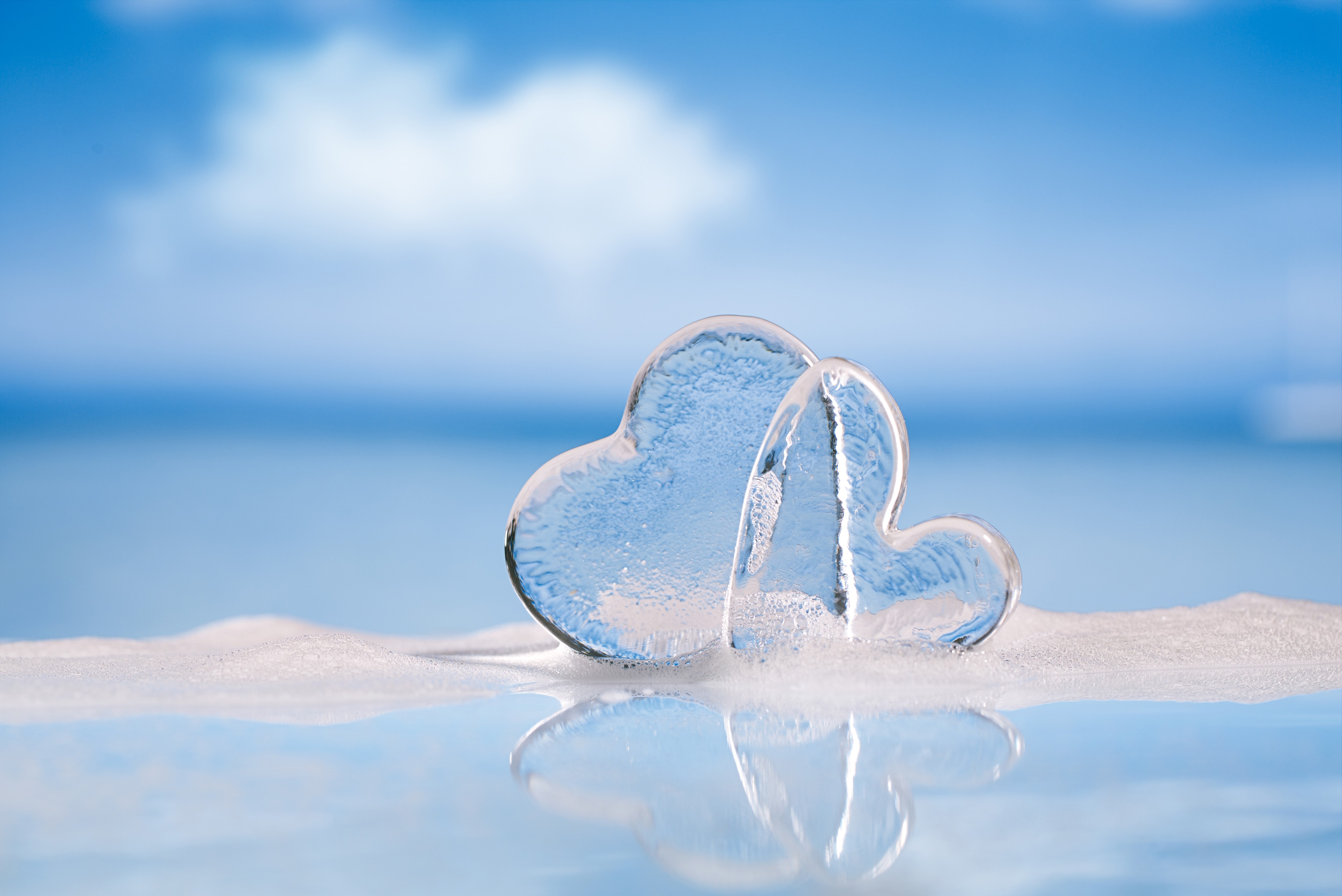 Two ice hearts on a beach with blue sky HD Wallpaper