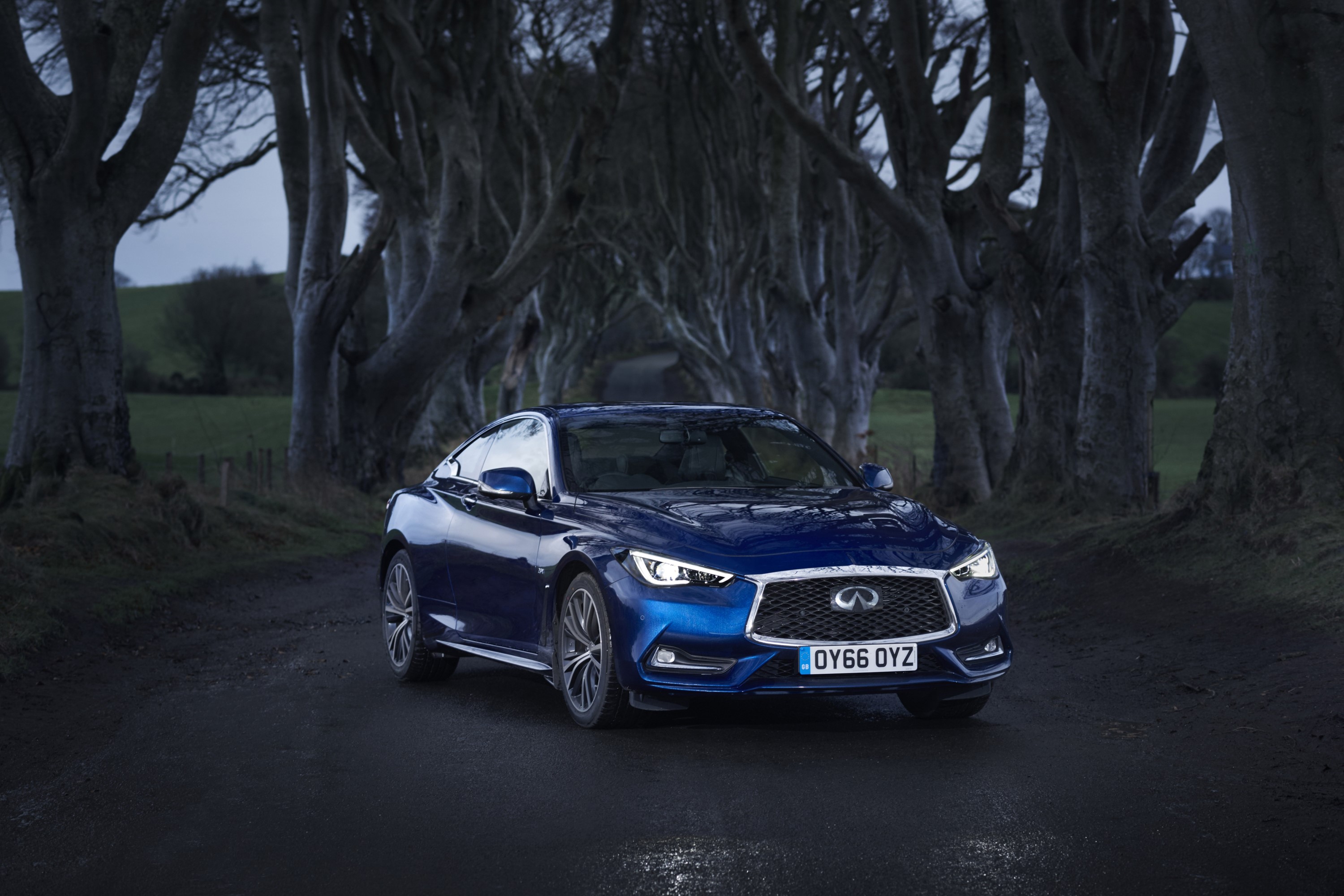Blue Infiniti Q60 2.0t coupe on a tree-lined road HD Wallpaper