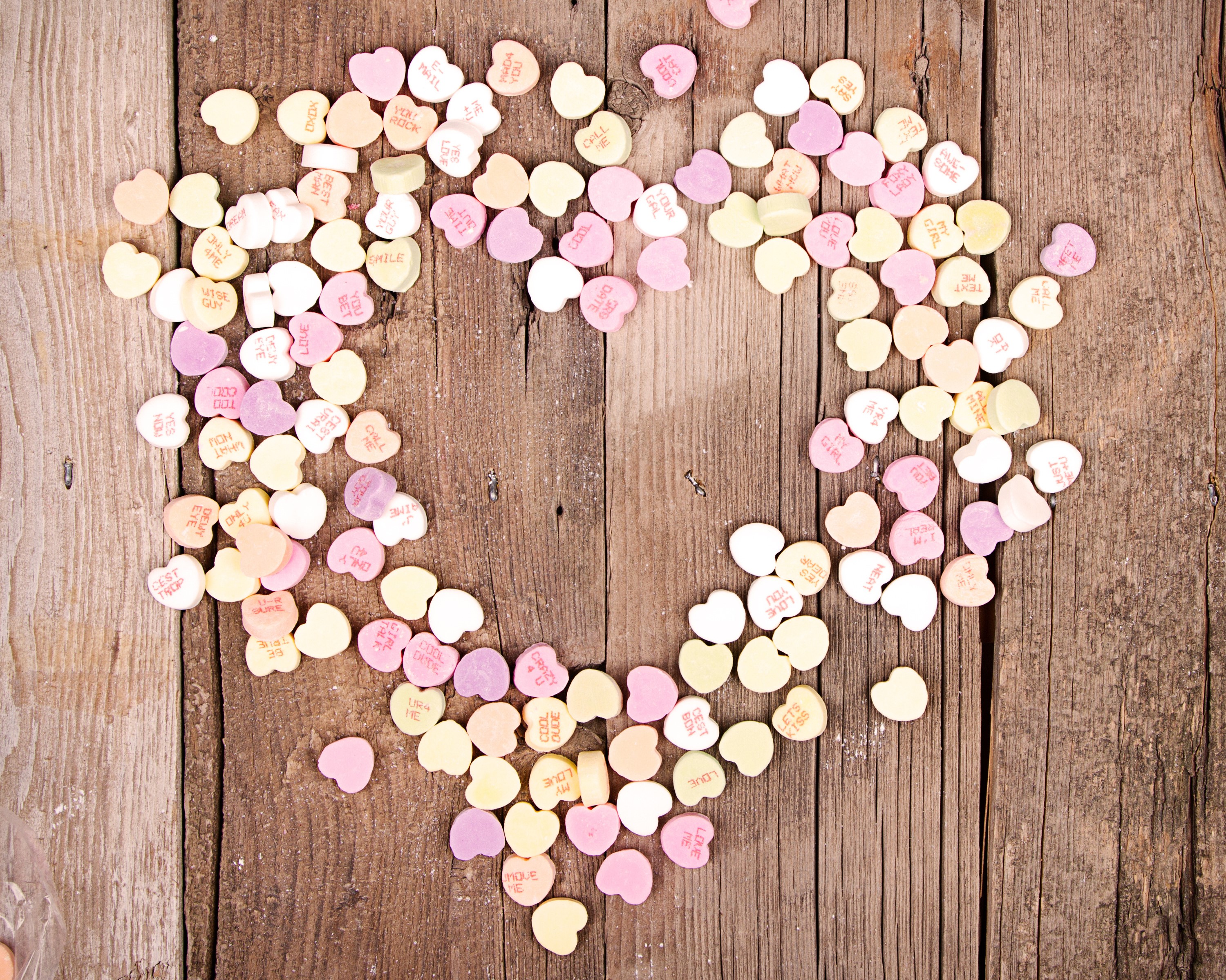 Heart shaped conversation candies on wood HD Wallpaper