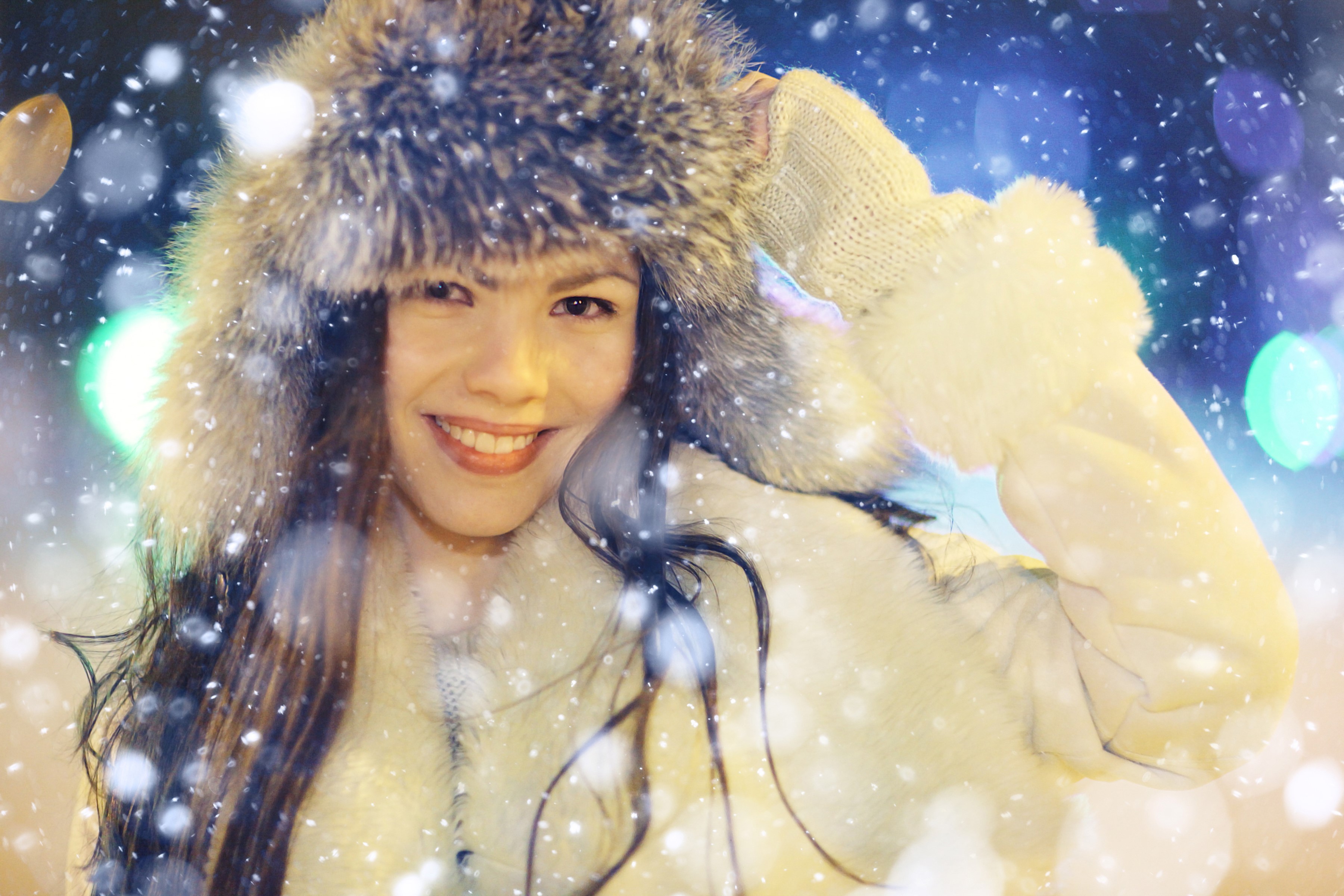 Woman in fur hat smiling in the snow HD Wallpaper